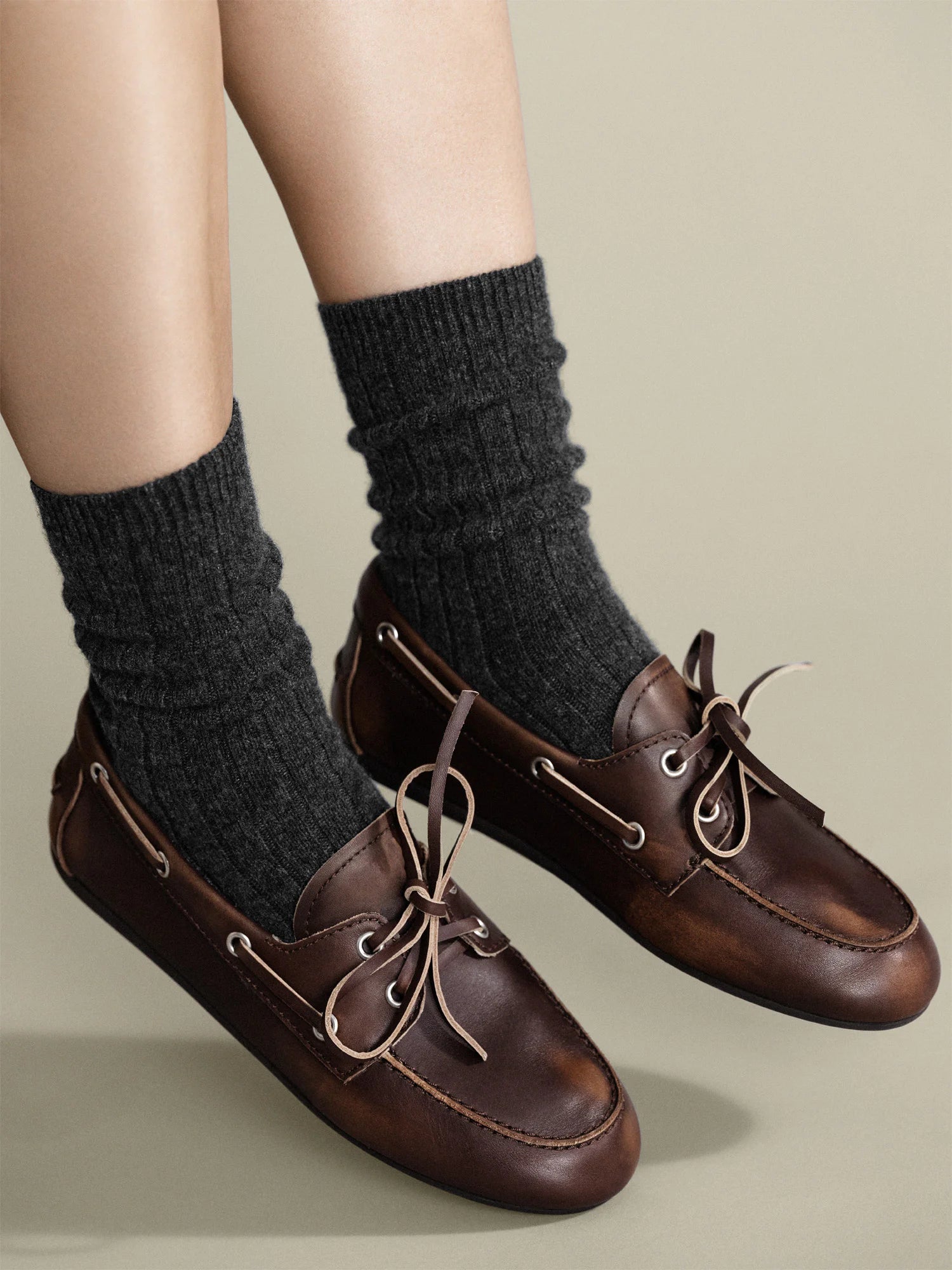 Charcoal gray ribbed socks, scrunched above dark brown shoes.