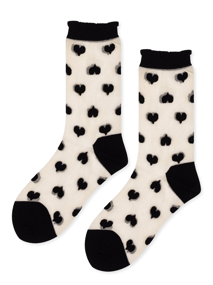 Sheer crew socks in cream feature black heart print, a black toe and heel, and a ruffled black cuff.