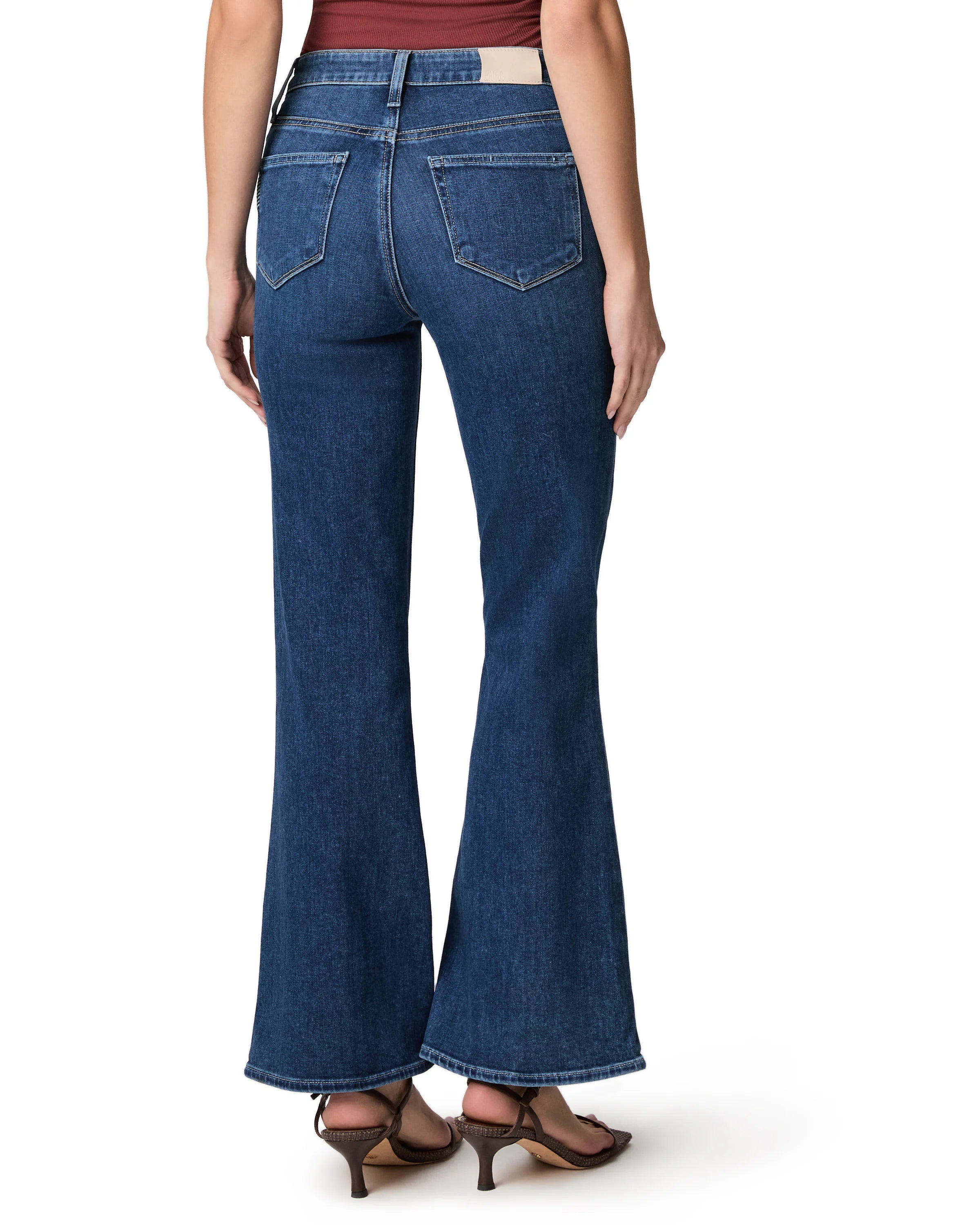 Dark blue high-waisted flared jeans with back pockets and a tan patch, cropped length.