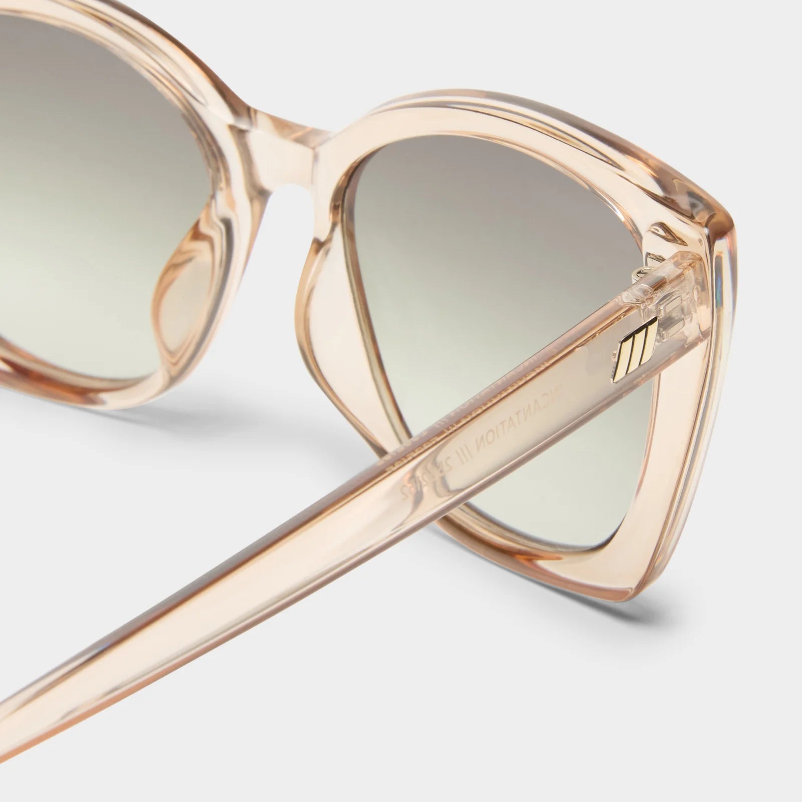 These oversized sunglasses feature translucent champagne frames, gradient lenses, and a gold-tone temple detail.