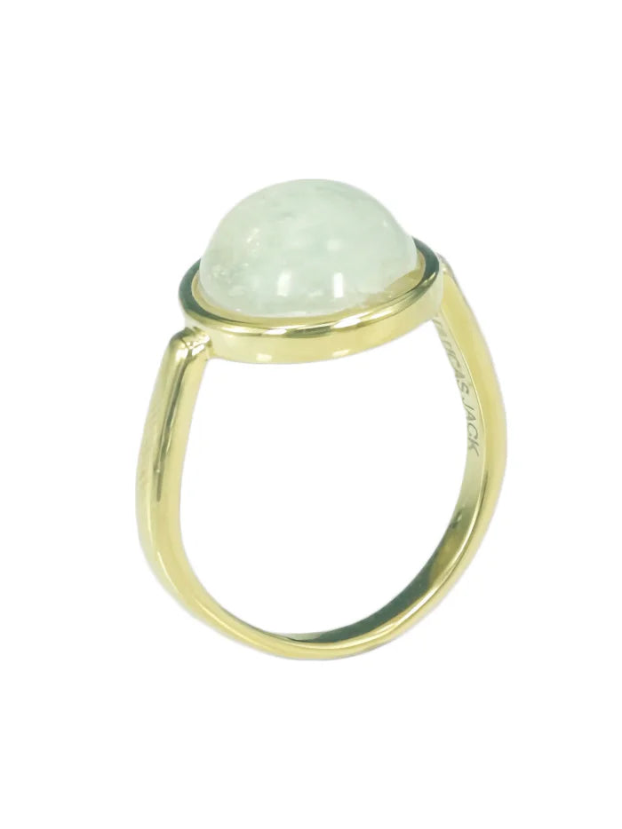 Gold ring with a domed, pale green, translucent stone.