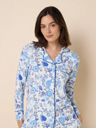 White long-sleeve pajama set with blue floral and cat print, accented by blue piping on collar and cuffs.