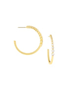 Gold-toned open hoop earrings. One side features a row of clear round crystals; the other side is smooth metal.