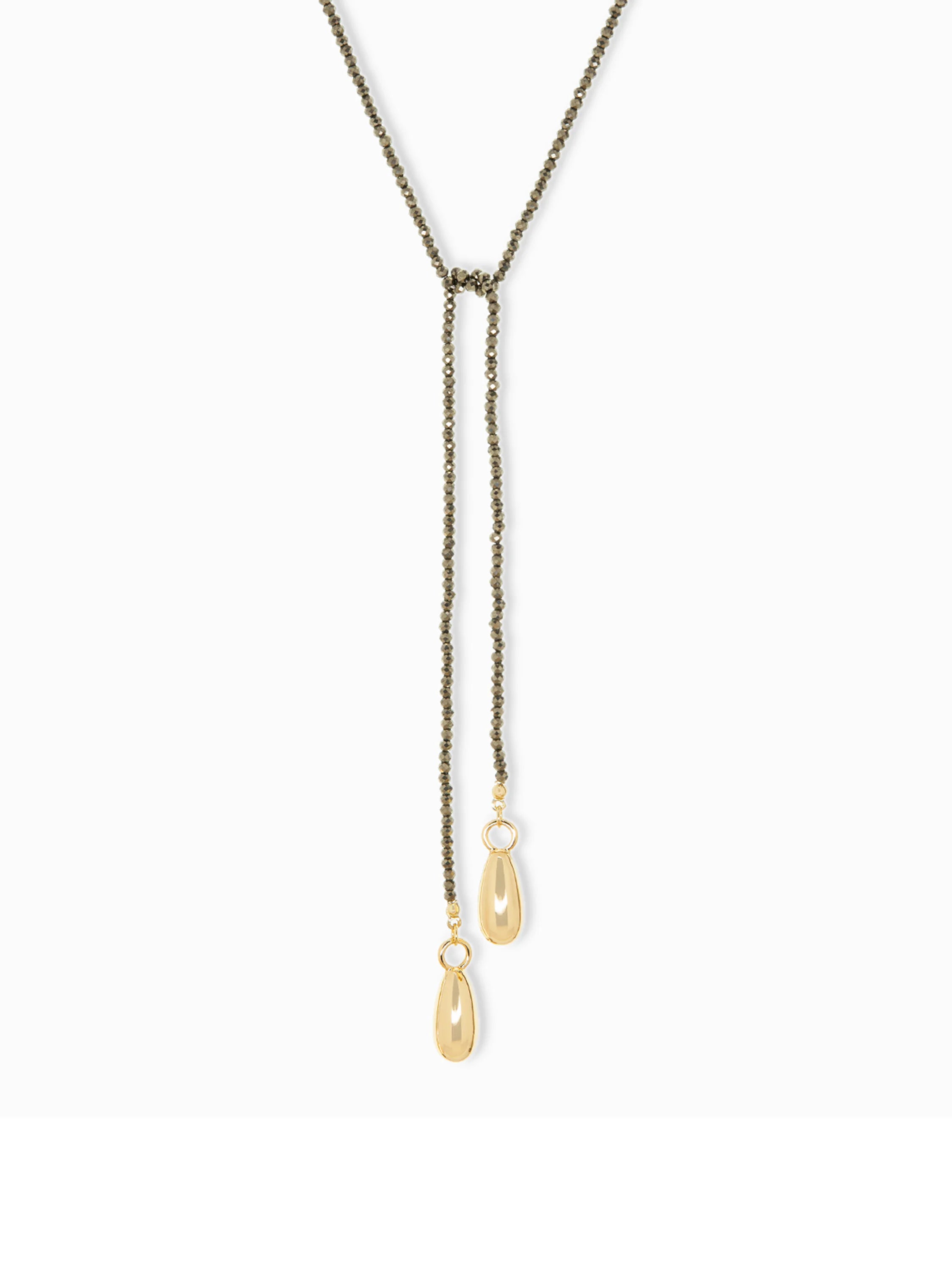 Here's some alt text that meets the requirements:
Dark-grey beaded lariat necklace with two gold teardrop charms.