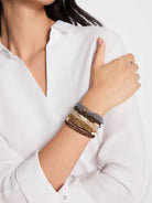 Stack of beaded stretch bracelets with pearls and gold accents. Colors: brown, gold, cream, olive, blue-grey.