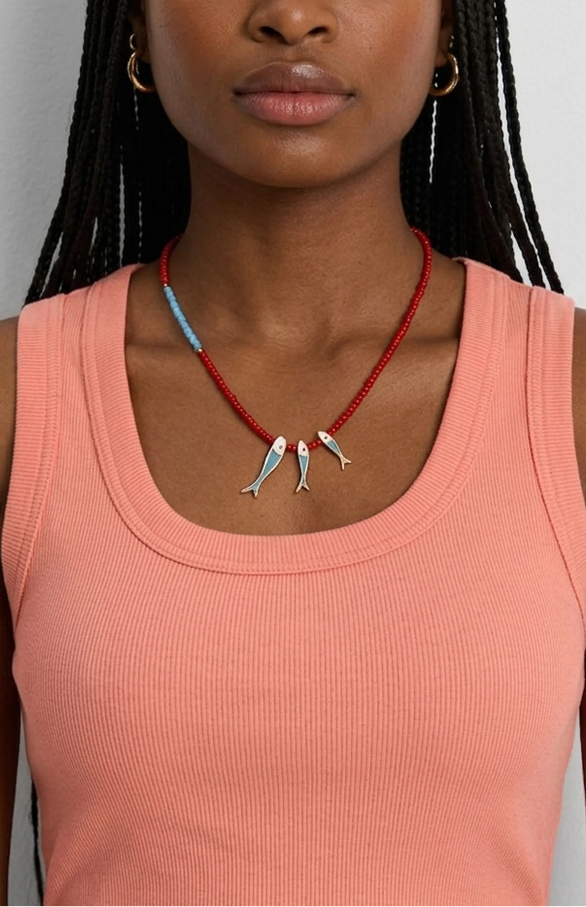 Necklace with red and light blue beads, three silver fish charms with blue details.