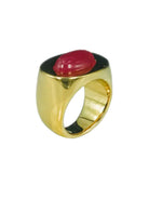 Wide gold ring with a domed red oval stone set on a black oval top.