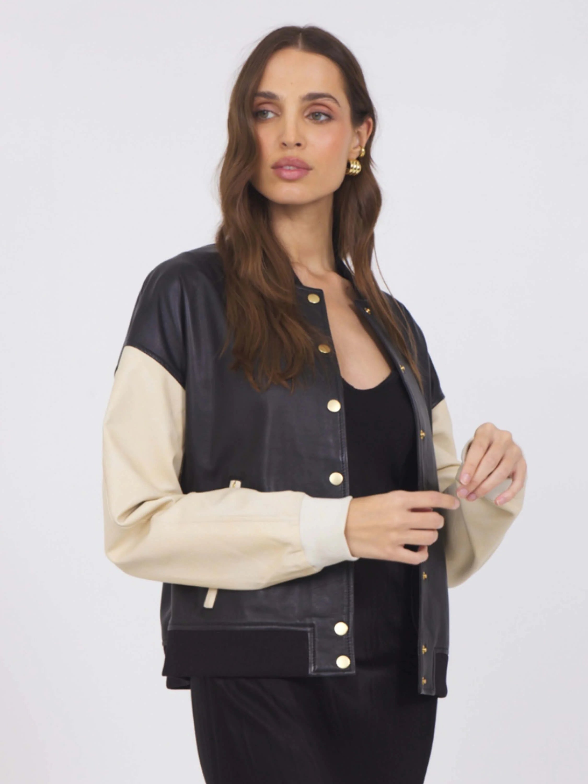 Black leather baseball jacket with beige sleeves & gold buttons. Knit cuffs & hem.