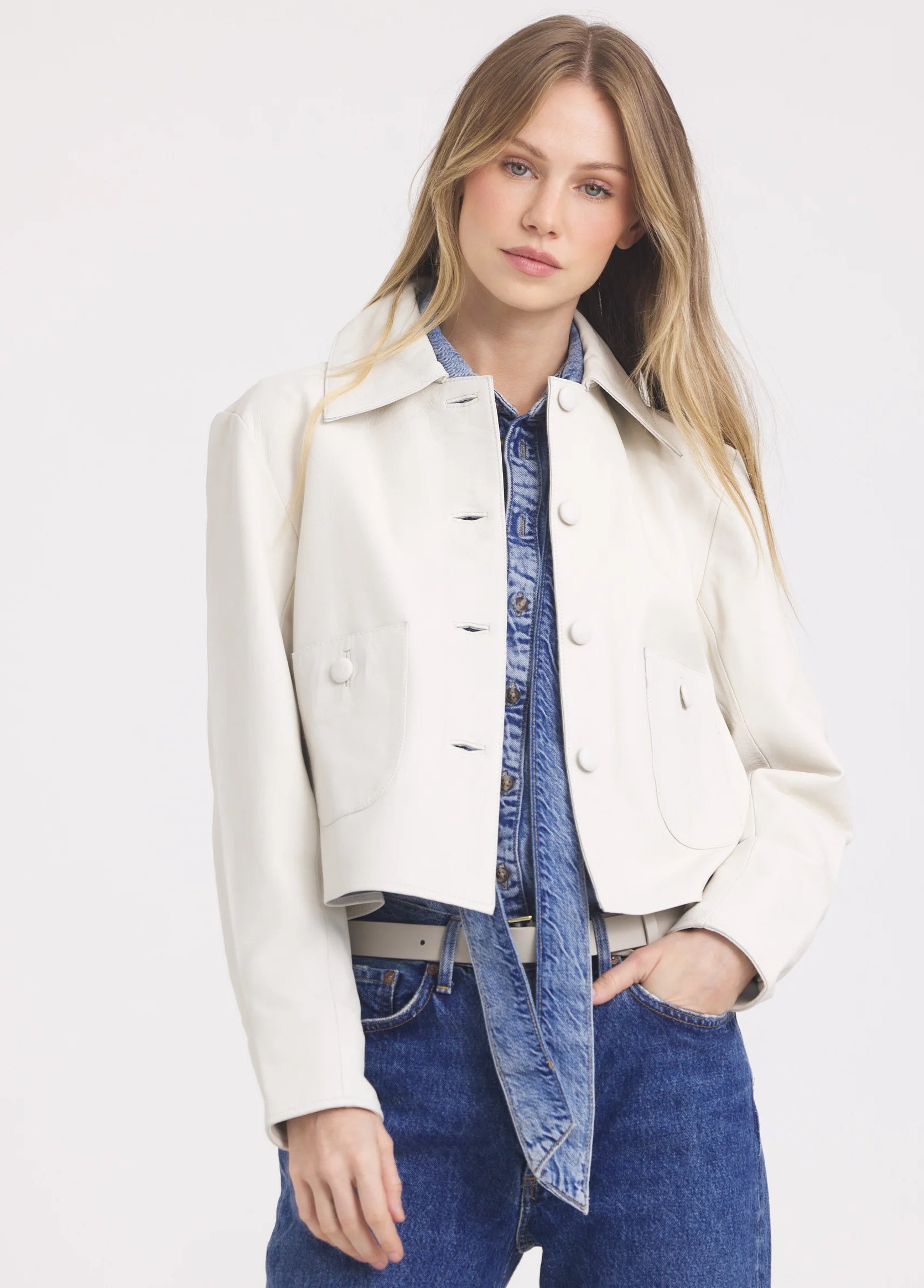 Cream cropped leather jacket with collar, front buttons, and two large chest pockets.