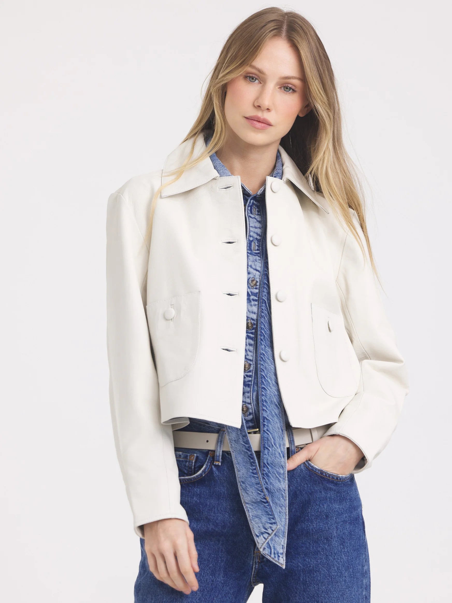 Cream cropped leather jacket with collar, front buttons, and two large chest pockets.