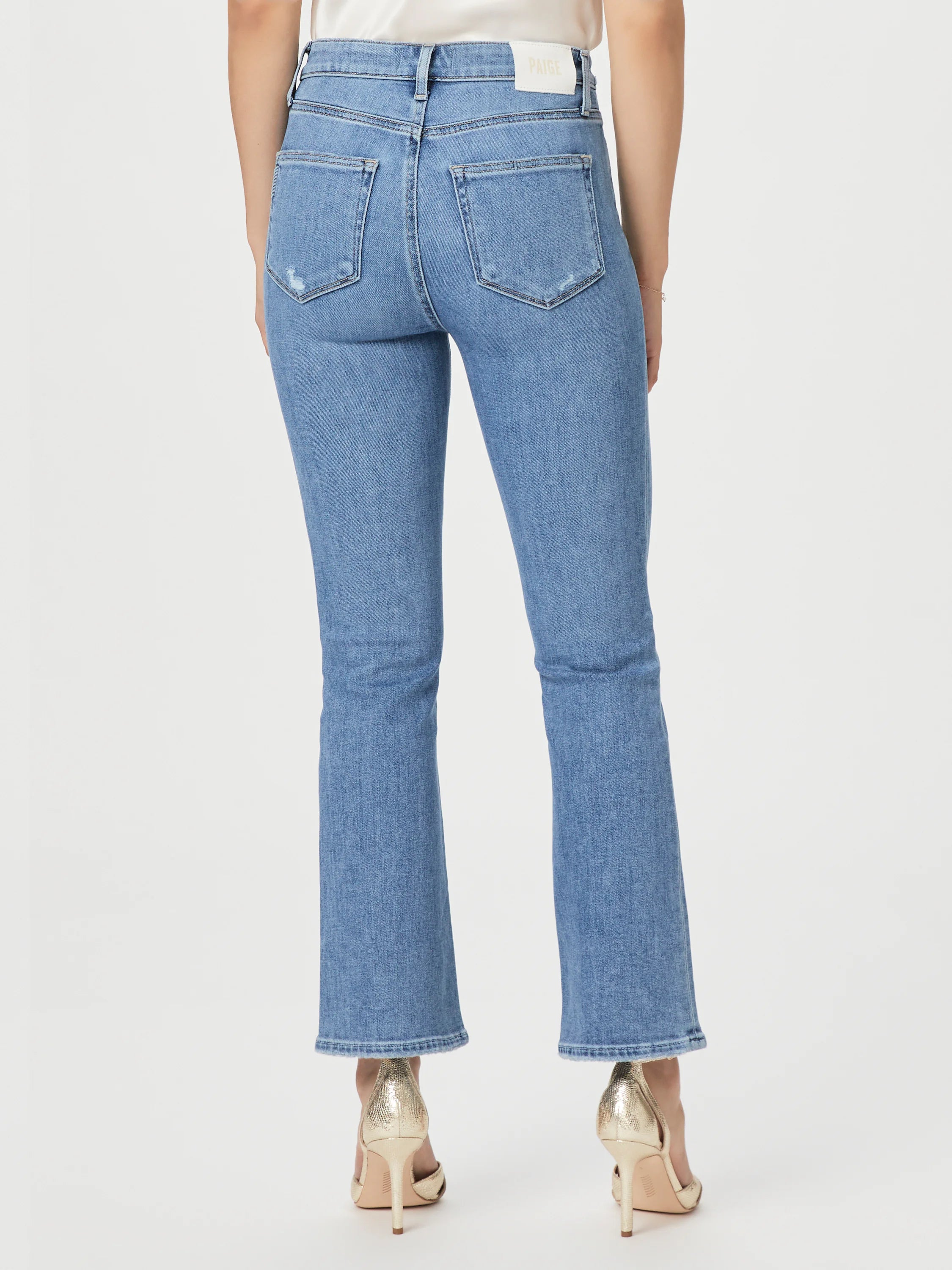 Light wash blue, bootcut jeans; slight distressing; linear coin pocket detail. Back view.