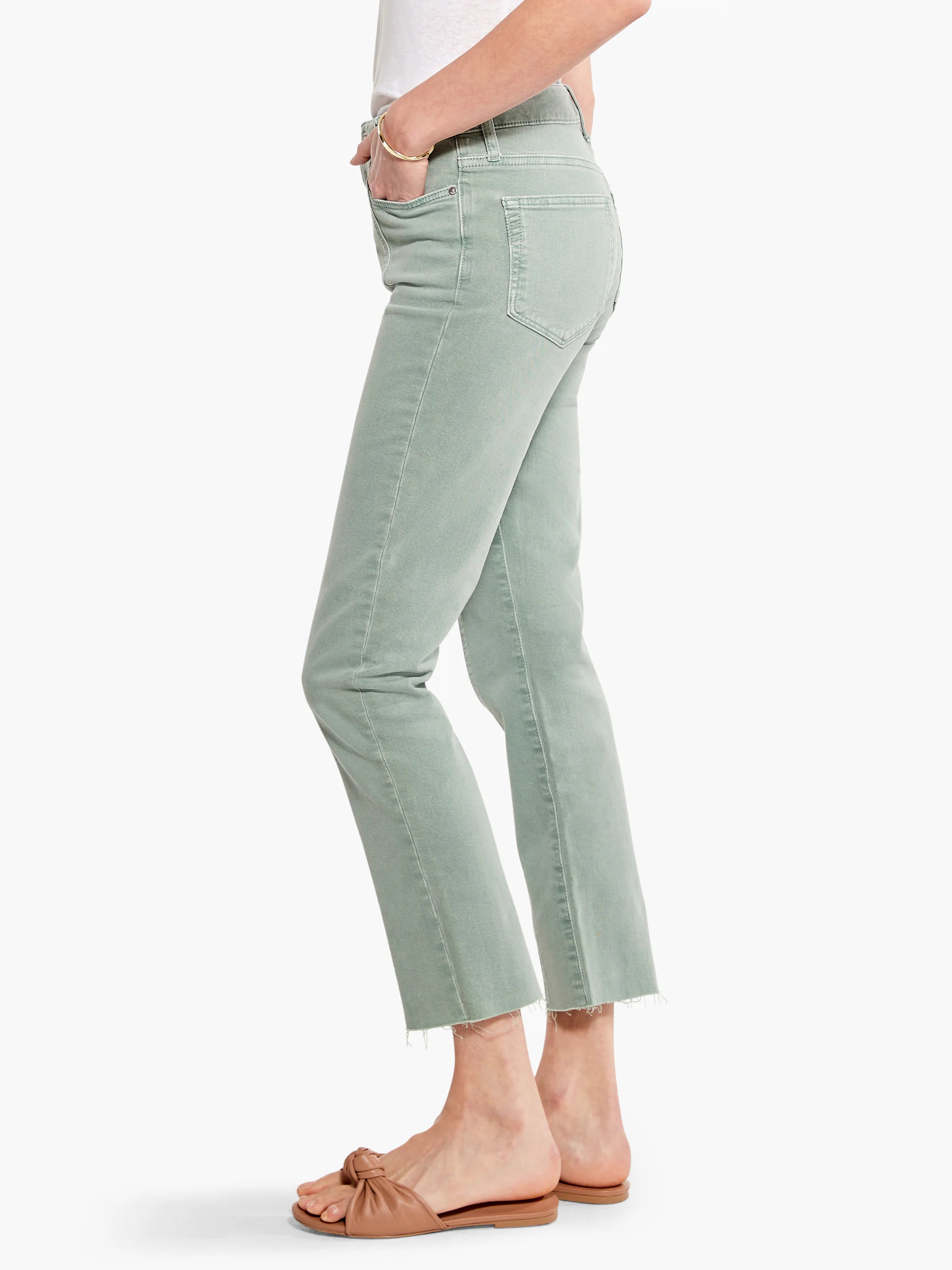 Sage green straight-leg jeans, raw hem, front seams. Model wears light brown sandals.