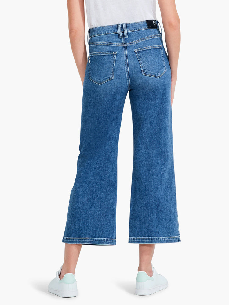 Here's alt text for the image, under 125 characters:
"Back view of medium-wash blue wide-leg jeans. Jeans have a...
