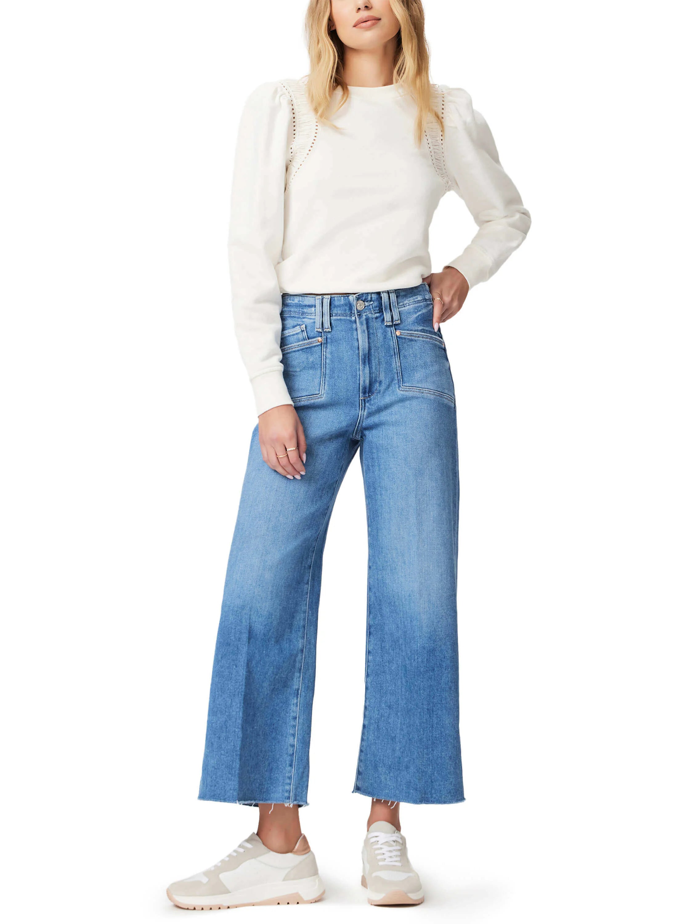 Light wash, wide-leg jeans with frayed hems; model wears off-white top.