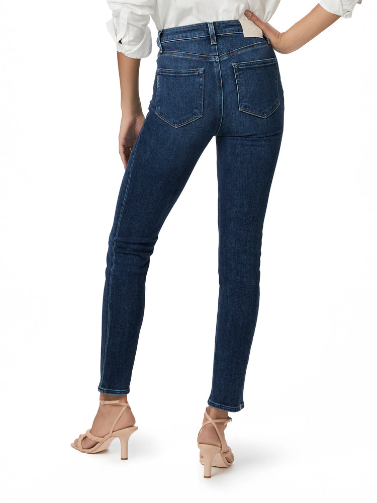 Dark wash blue jeans, straight leg, shown from the back. The model is wearing light beige heels.