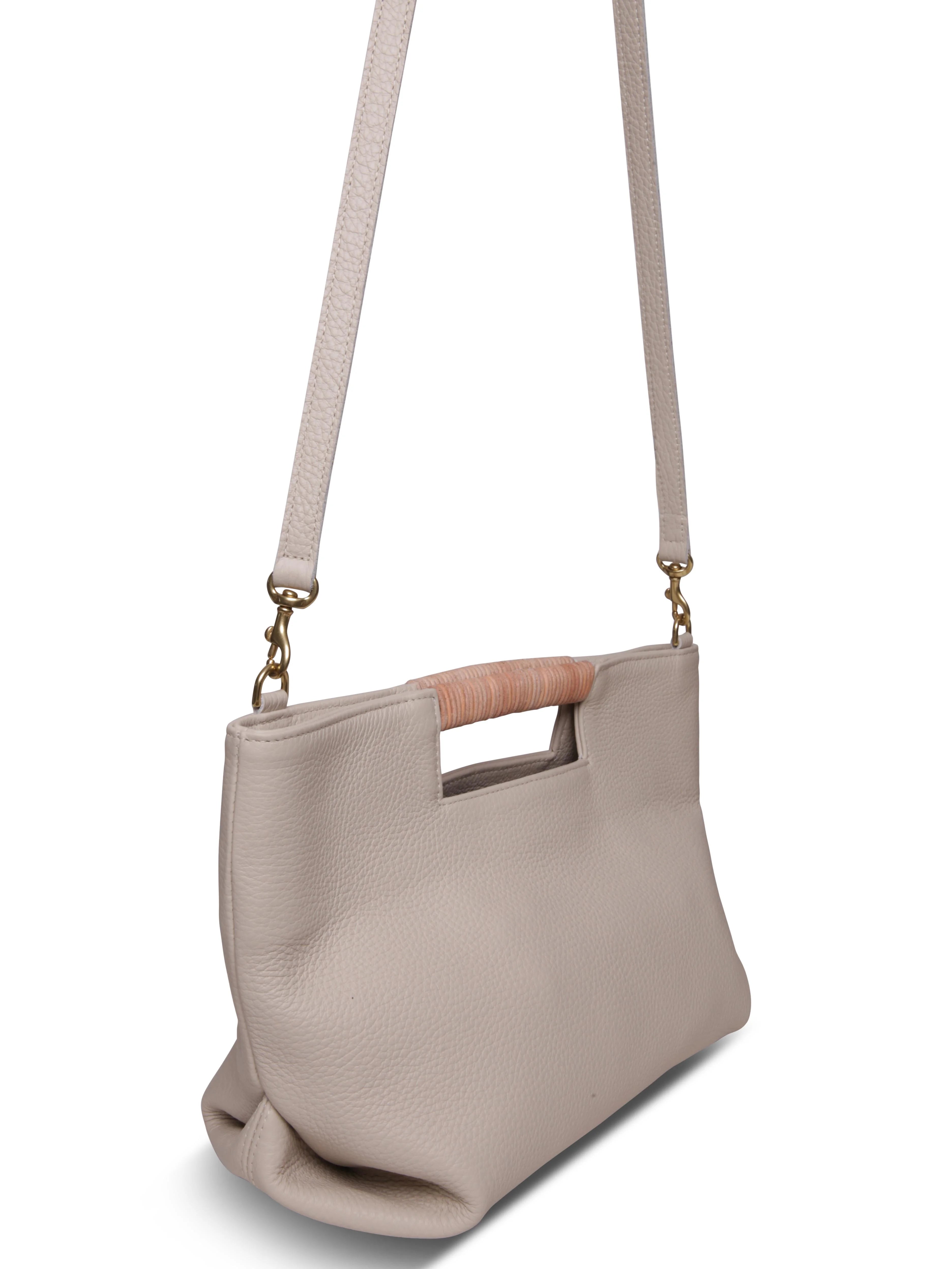 Beige leather crossbody bag with light brown wooden top handle and gold clasps. Shoulder straps included.