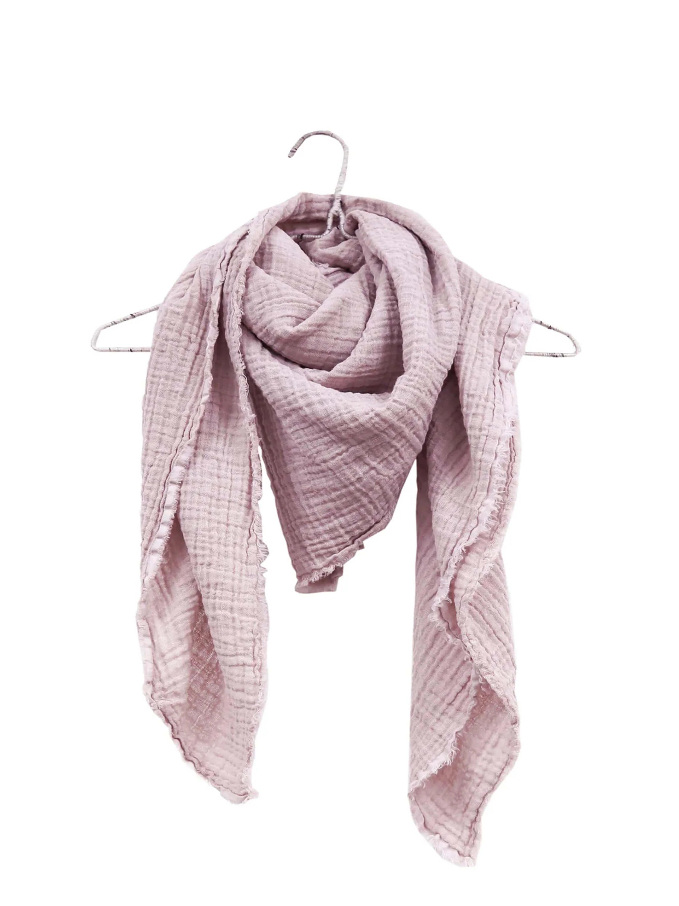 Crinkled dusty pink gauze scarf with frayed edges, draped loosely over a hanger.