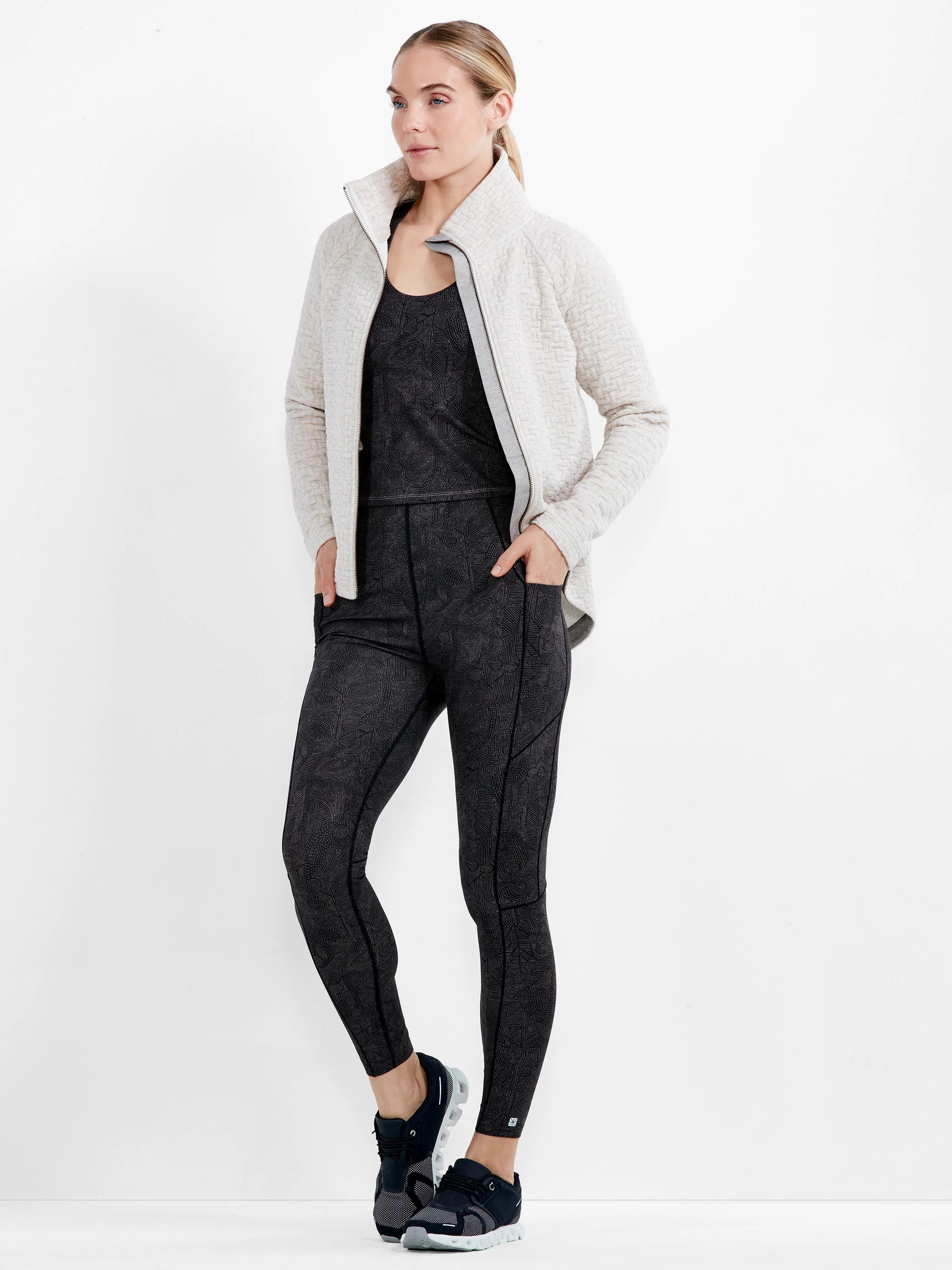 Light cream quilted jacket with a full-zip front, high collar, and side pockets.
