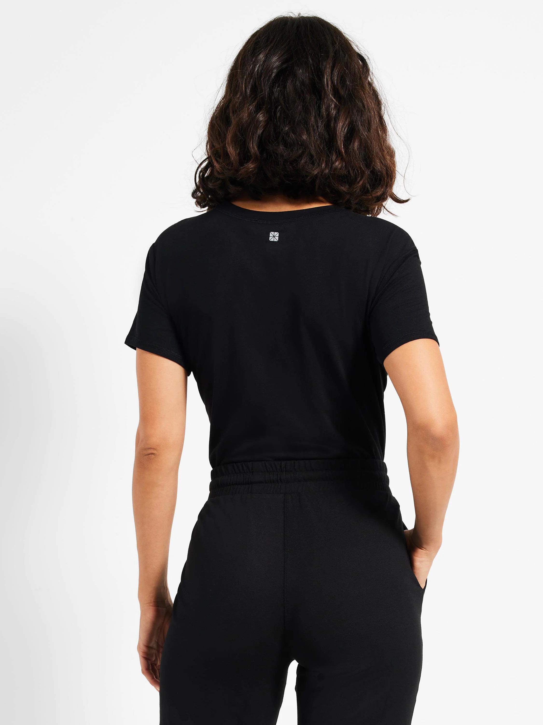 Black jogger pants; elastic waistband, pockets. Rear view.