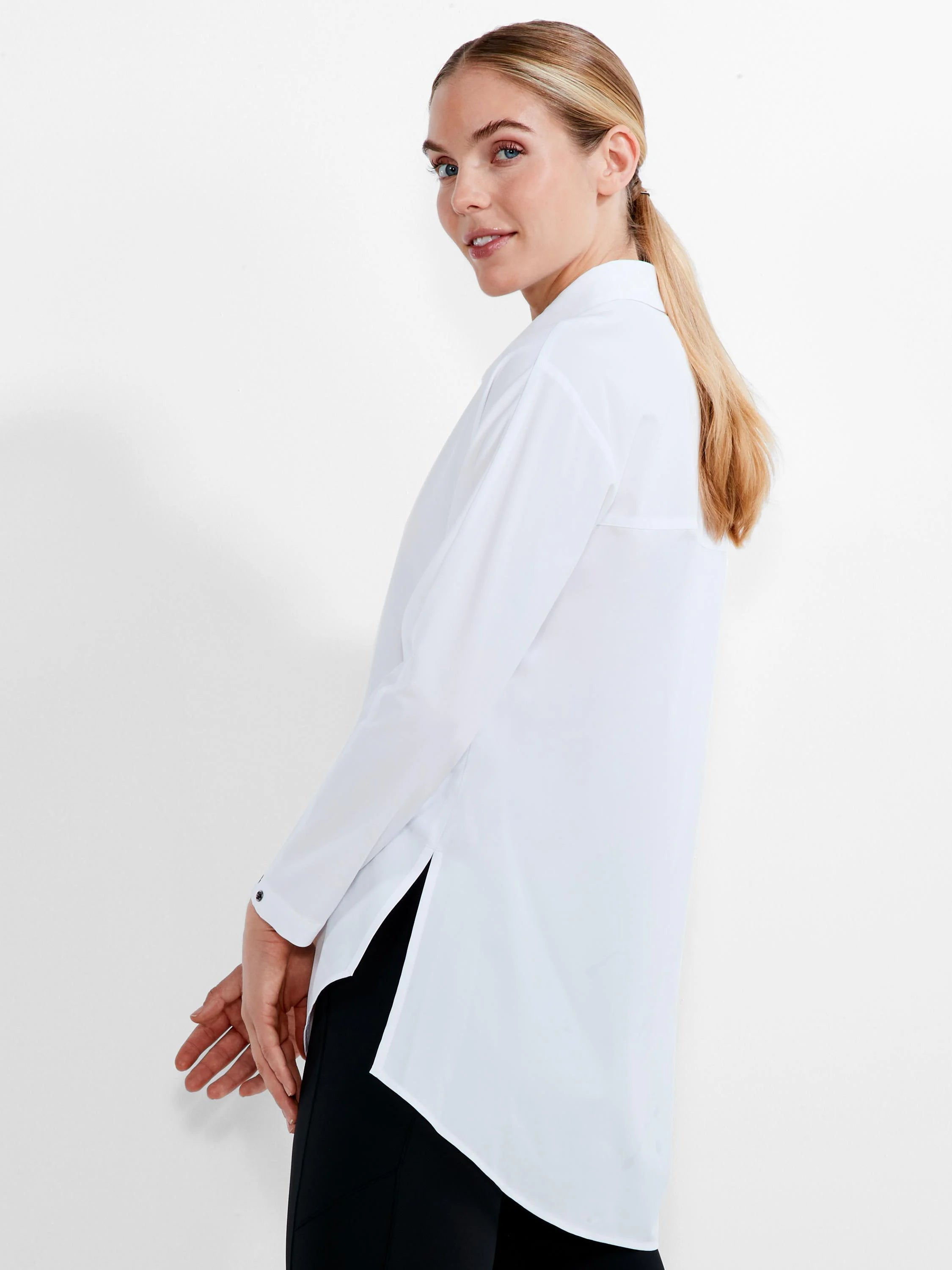 White collared long-sleeve shirt with black cuff buttons, side slits, and a curved hem.