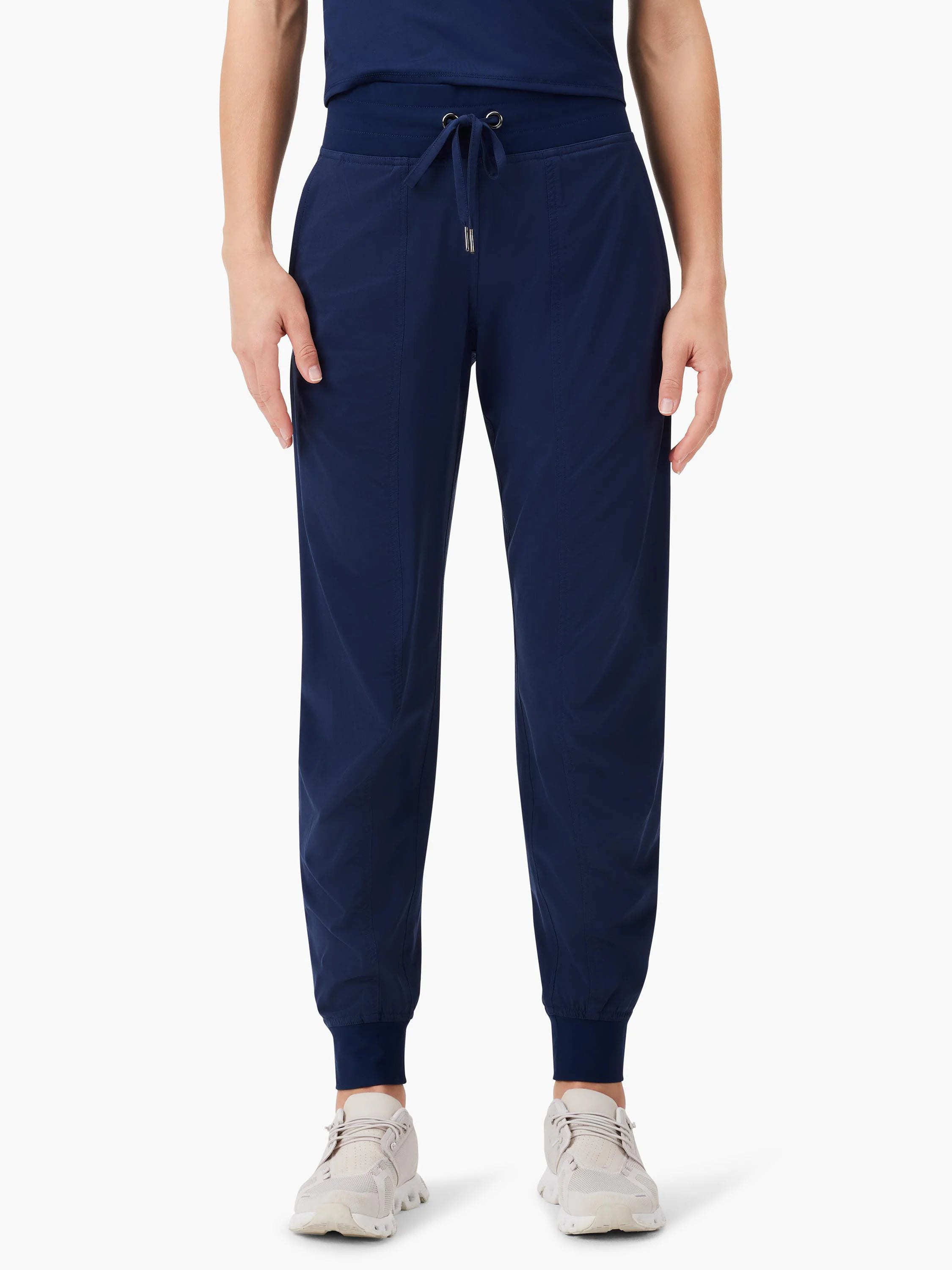 Dark blue jogger pants with a ruched elastic waistband, drawstring with silver tips, and cuffed ankles.