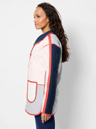 Reversible quilted coat, one side shows pink, navy, grey color blocks with coral trim.