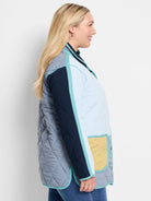 Quilted, color-blocked coat with light blue, gray, navy, and yellow panels outlined in teal piping.
