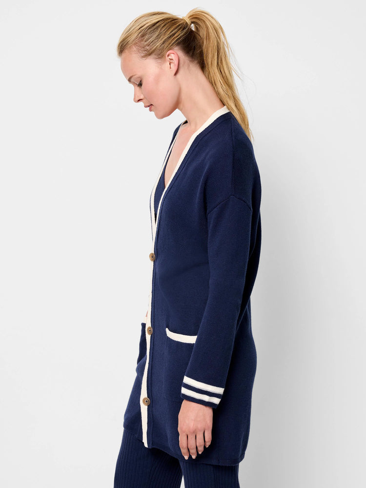 Navy blue cardigan with off-white trim on the placket, pockets, and cuffs. Button front.