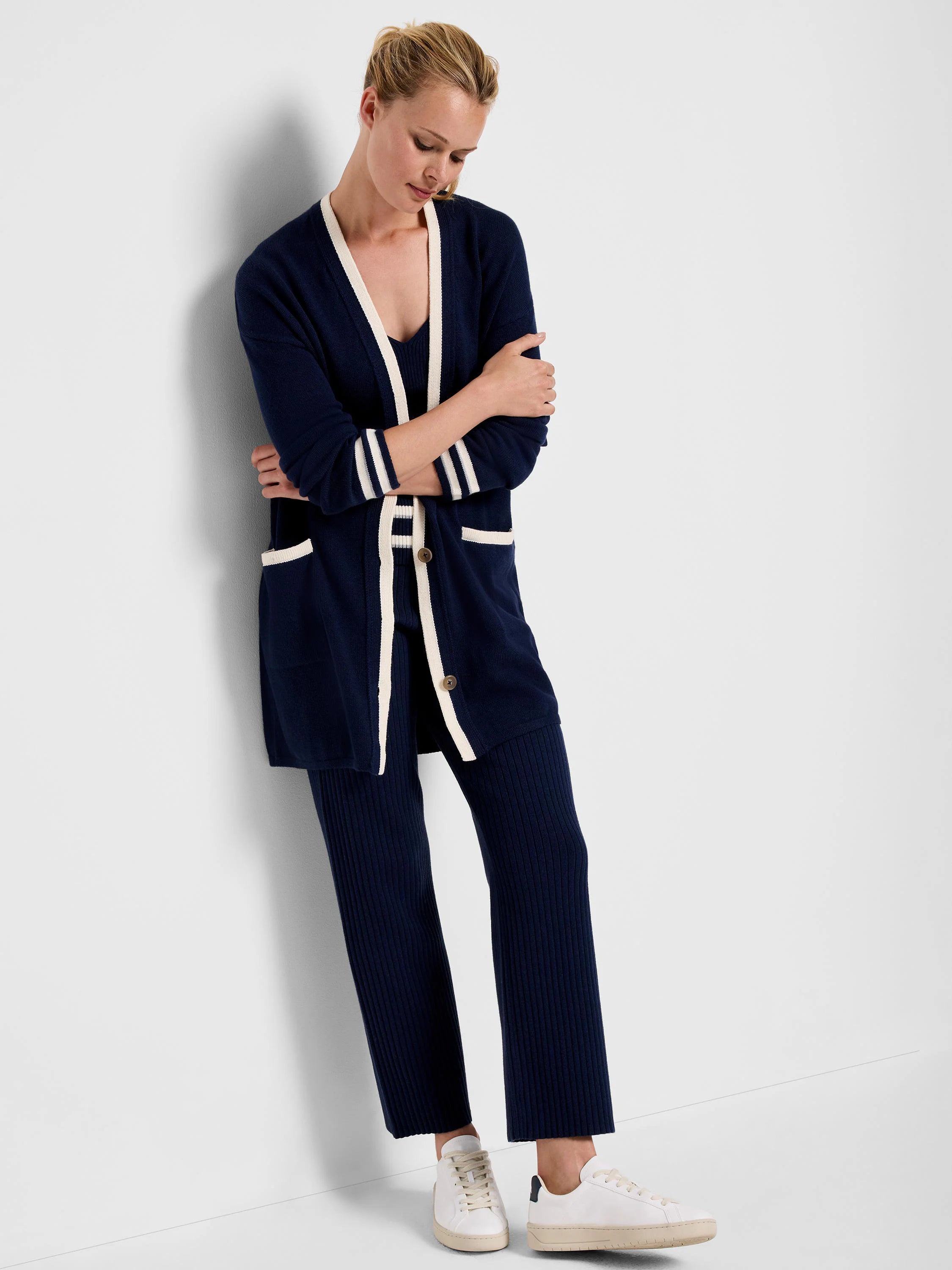 Navy blue ribbed knit pants. Off-white trim accents. Model also wears matching cardigan.