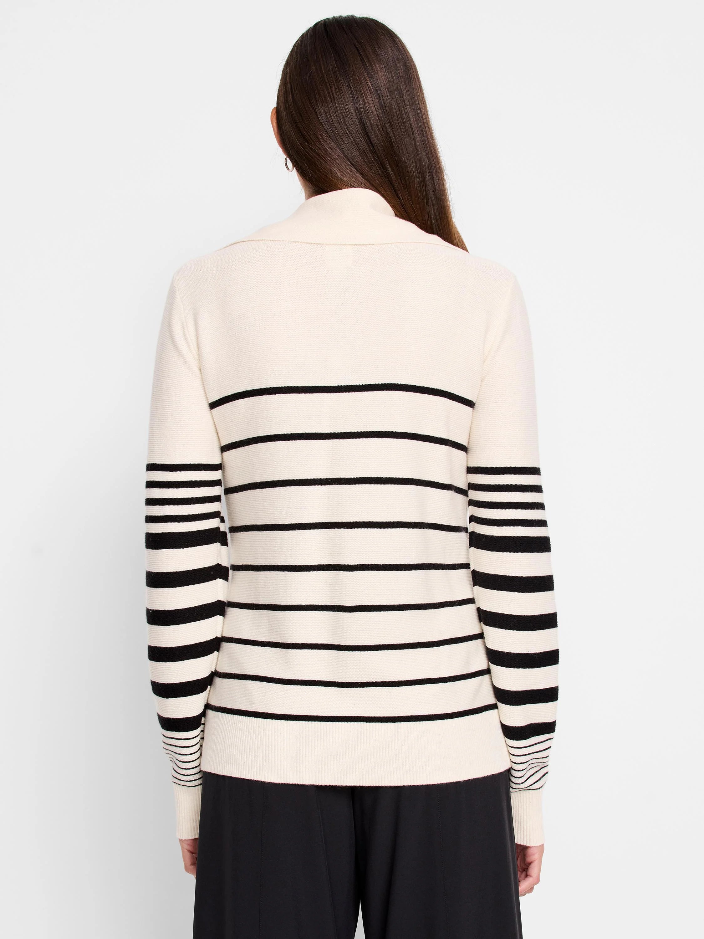 Cream-colored sweater with horizontal black stripes on body and sleeves. Half-zip neckline.