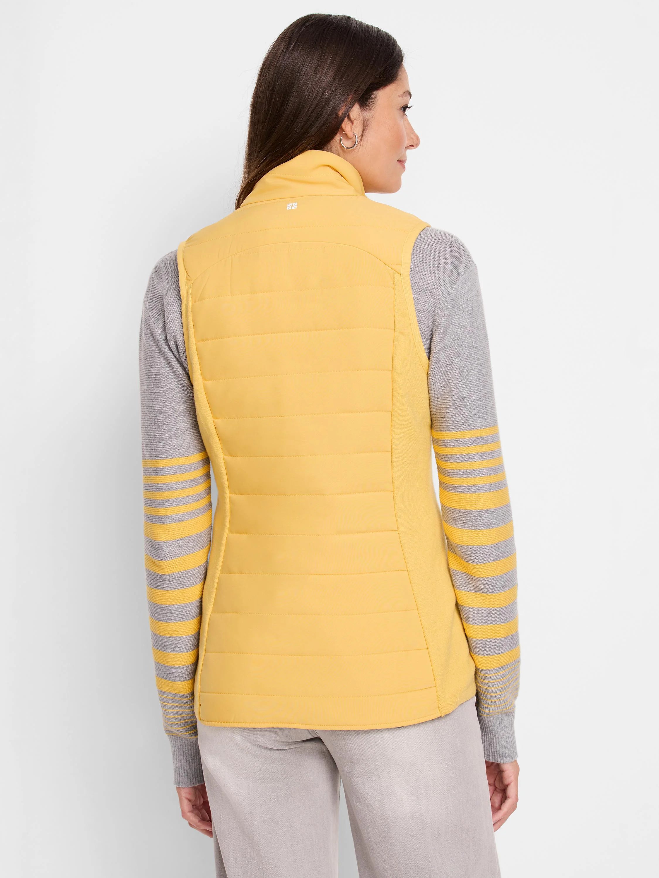 Mustard yellow quilted puffer vest, stand-up collar. Back view. Knit trim.