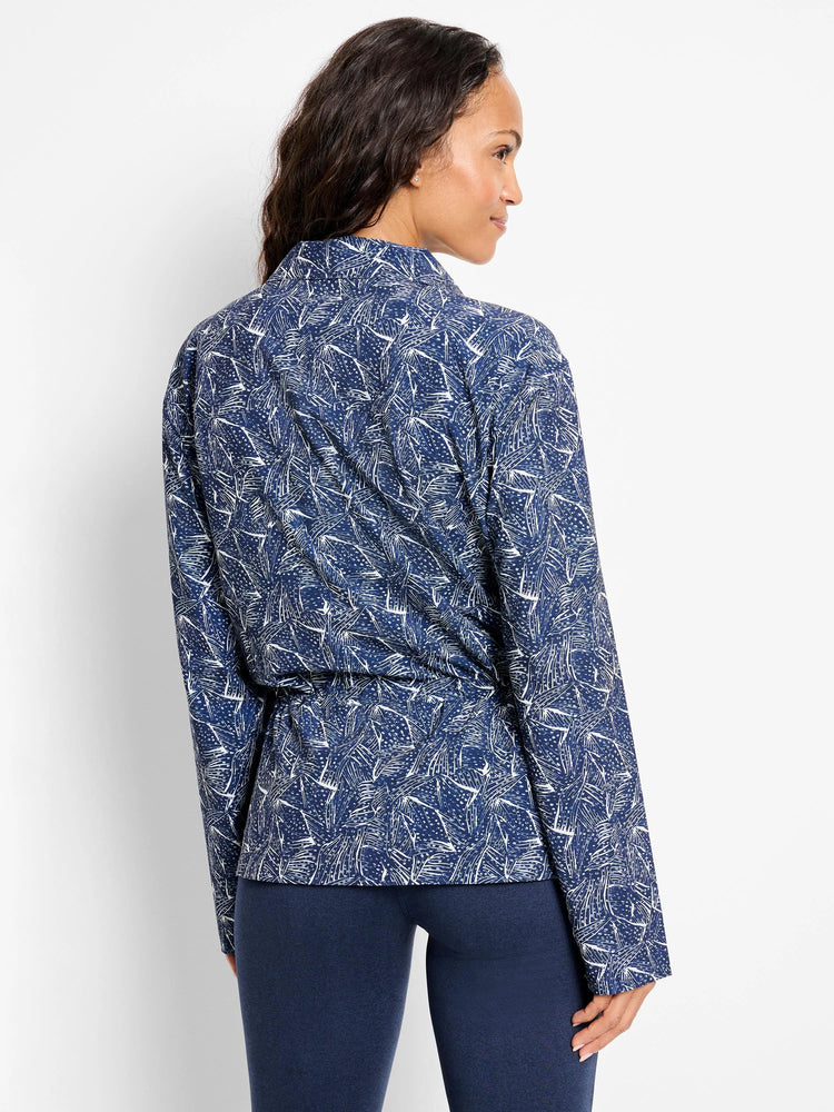 Navy blue zip-front jacket with a white abstract leaf print. Long sleeves. Model shown wearing dark navy leggings.