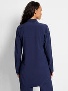 Navy blue long-sleeved collared shirt with a relaxed, tunic length fit and curved hem.