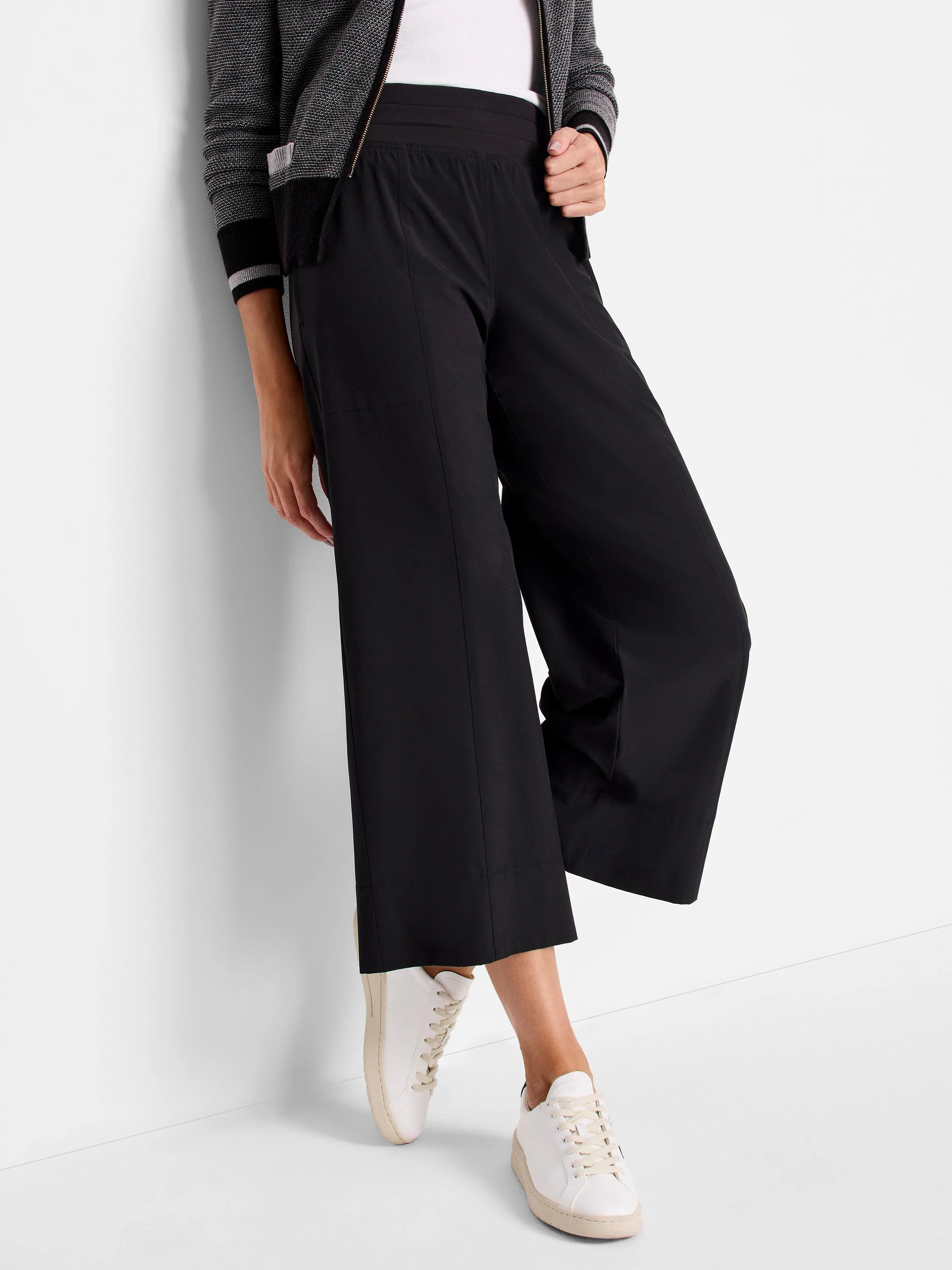 Black wide-leg cropped pants with an elastic waistband. Shown with white sneakers.