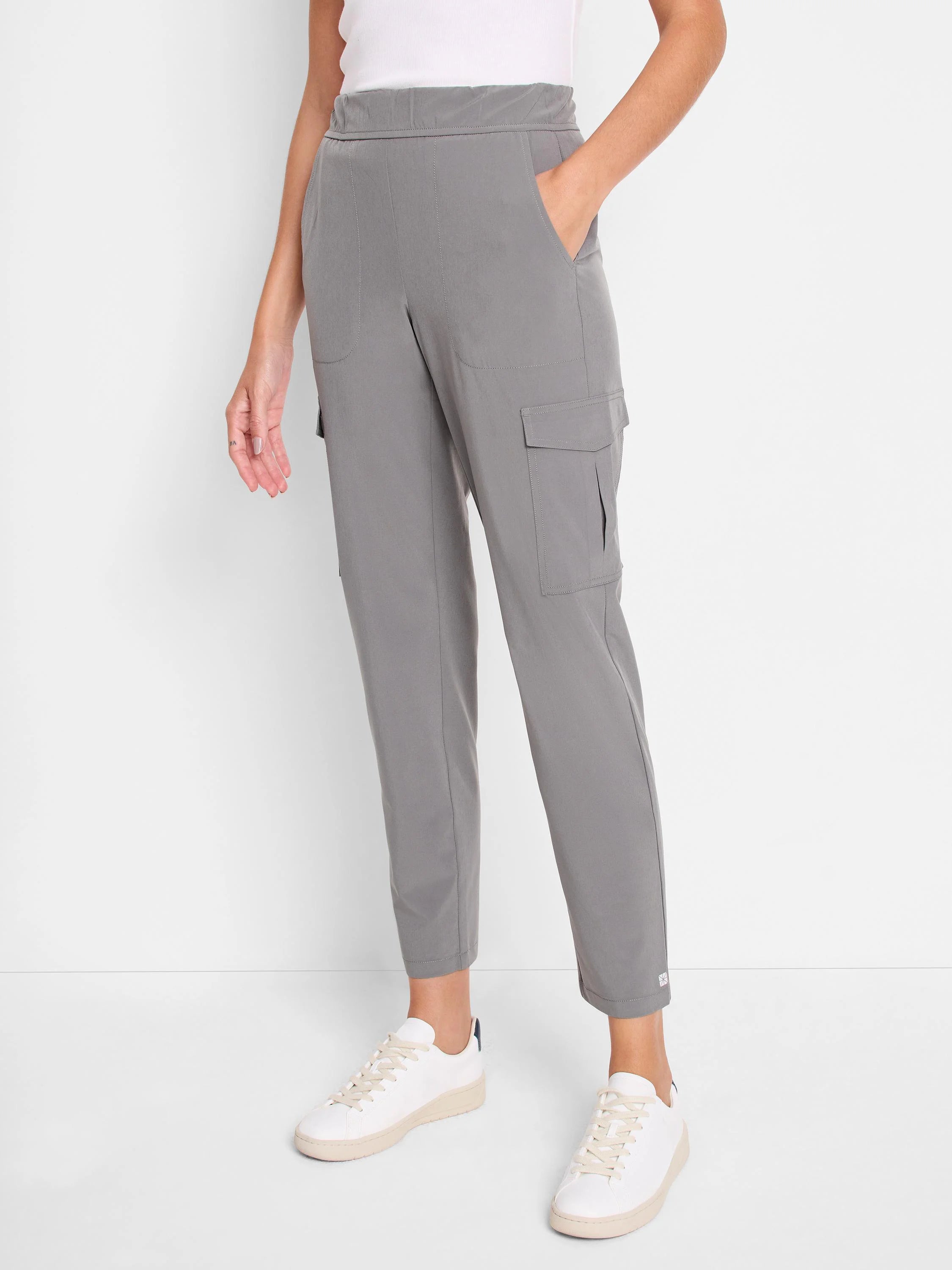Grey tech stretch cargo pants. Features a flat waistband, side pockets, and flapped cargo pockets on the legs. Cropped...