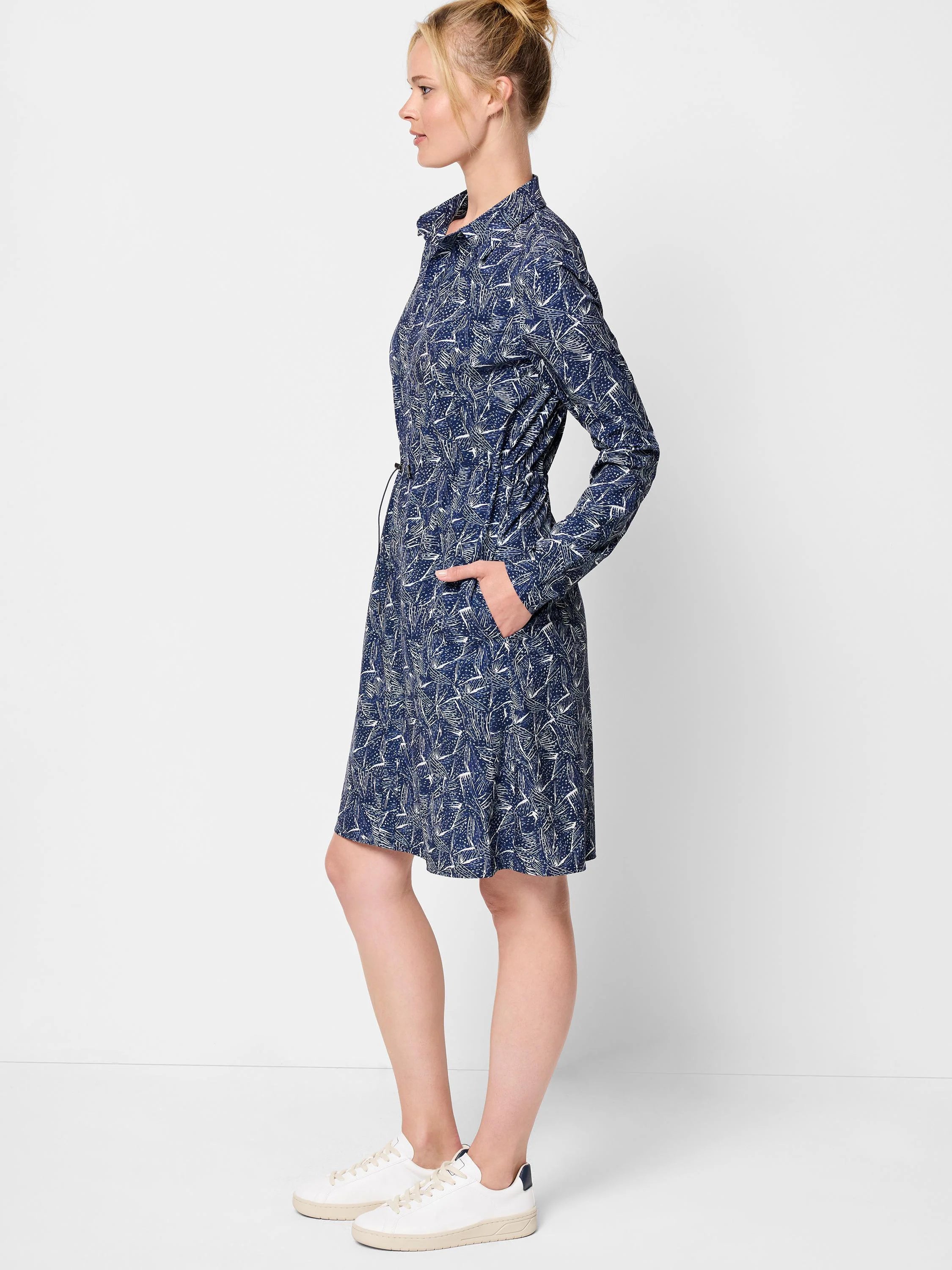 Navy blue mini dress with a white abstract print. Long sleeves, collared neckline, and drawstring waist. Features pockets.