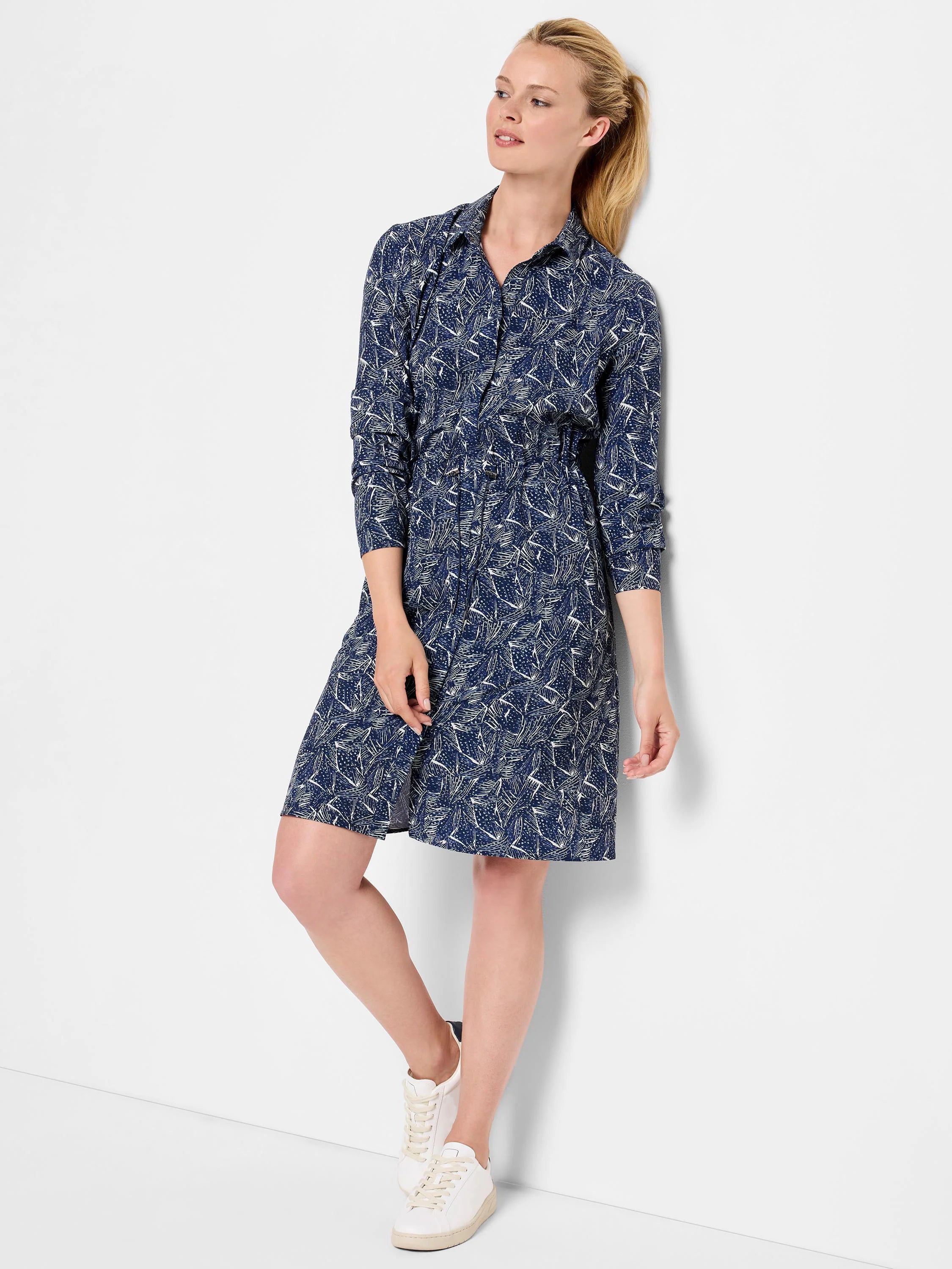 Navy blue dress with a white abstract print. Long sleeves, collared neckline, knee-length.