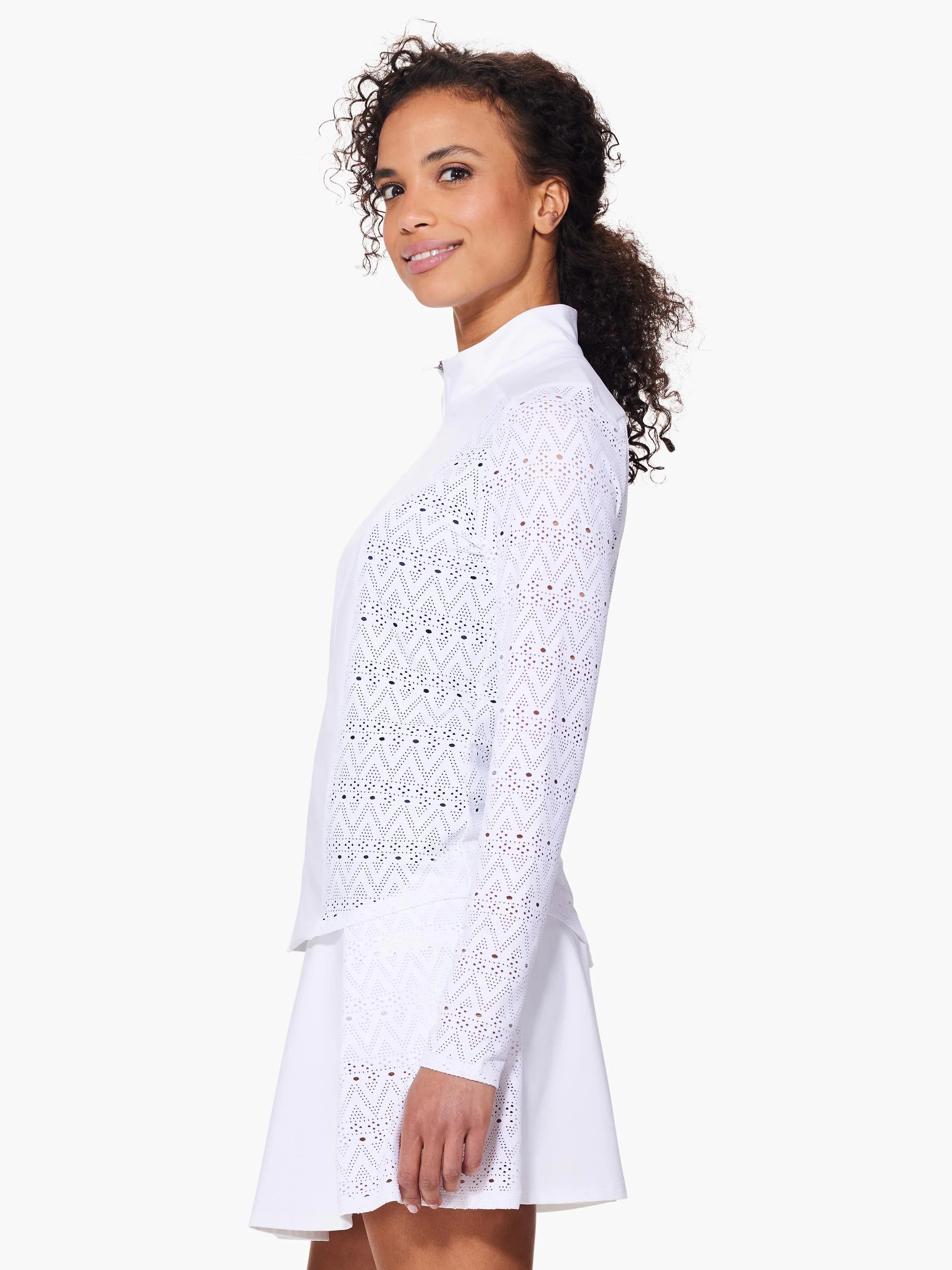 White long-sleeve jacket with a geometric eyelet pattern. Quarter-zip closure. Shown with white A-line skirt.