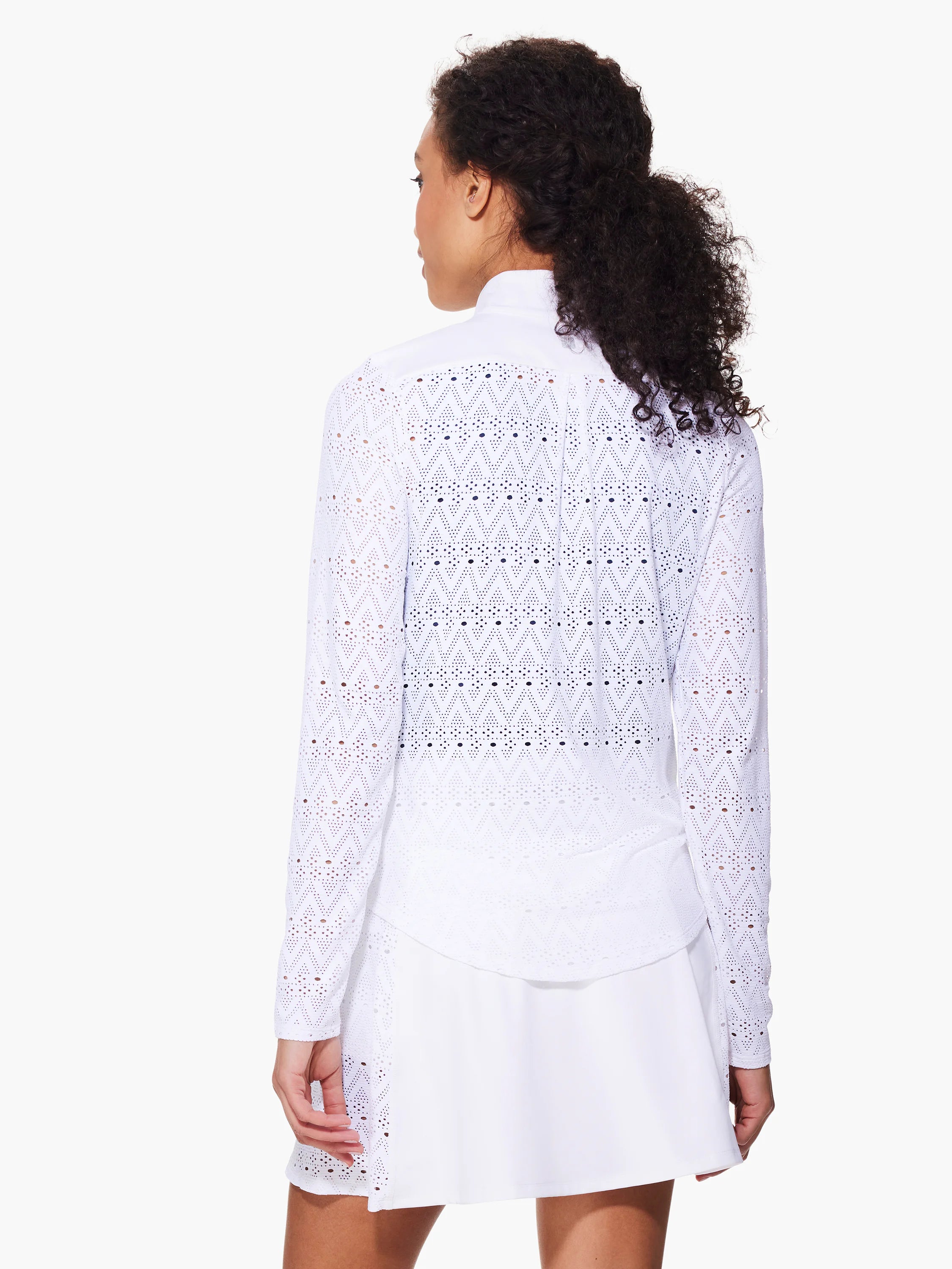 White long-sleeve jacket with repeating chevron and eyelet pattern. Shown with white A-line mini skirt.