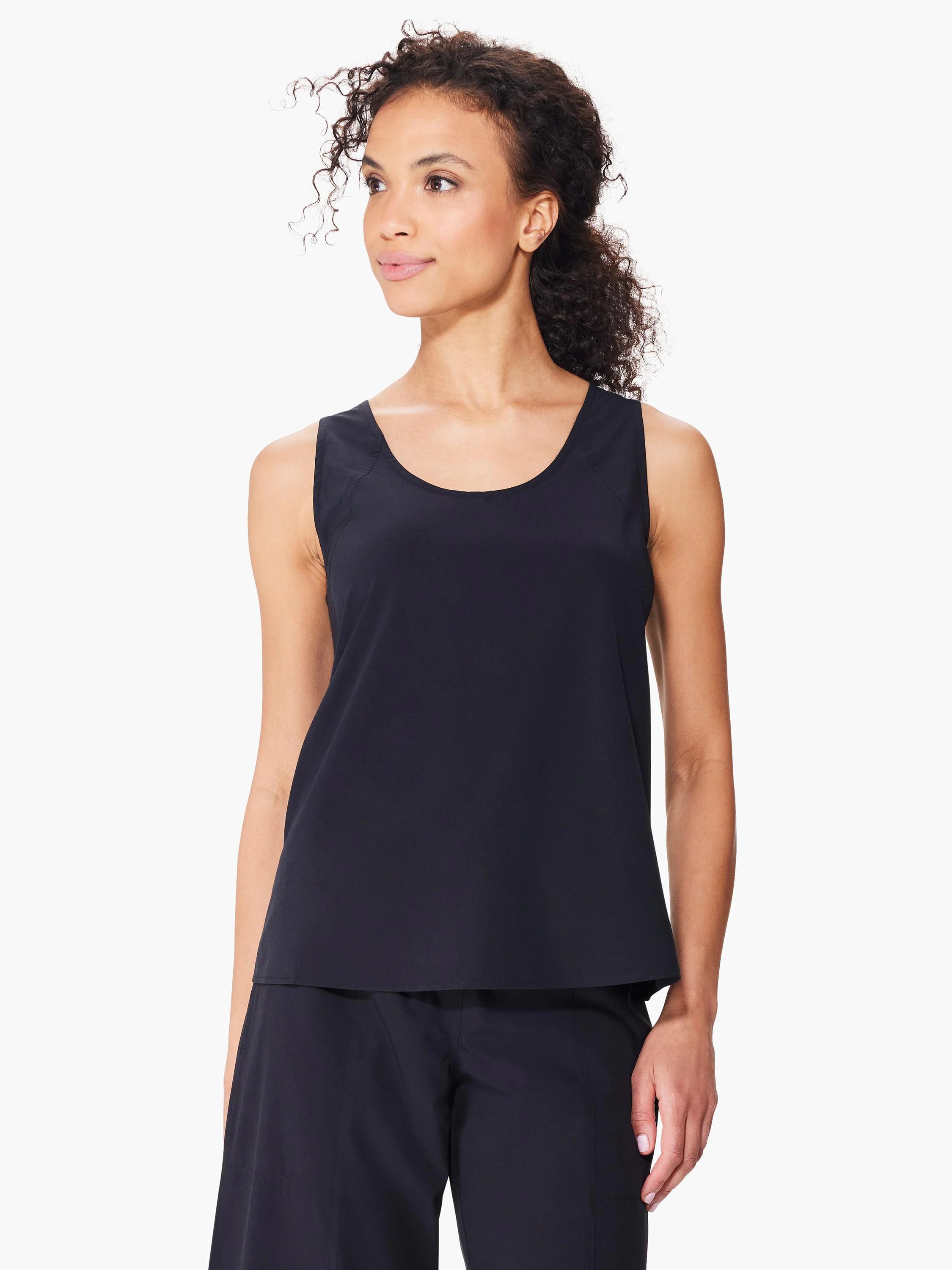 Black sleeveless shirt; scoop neck, seamed sides. Model shown wearing matching black bottoms.