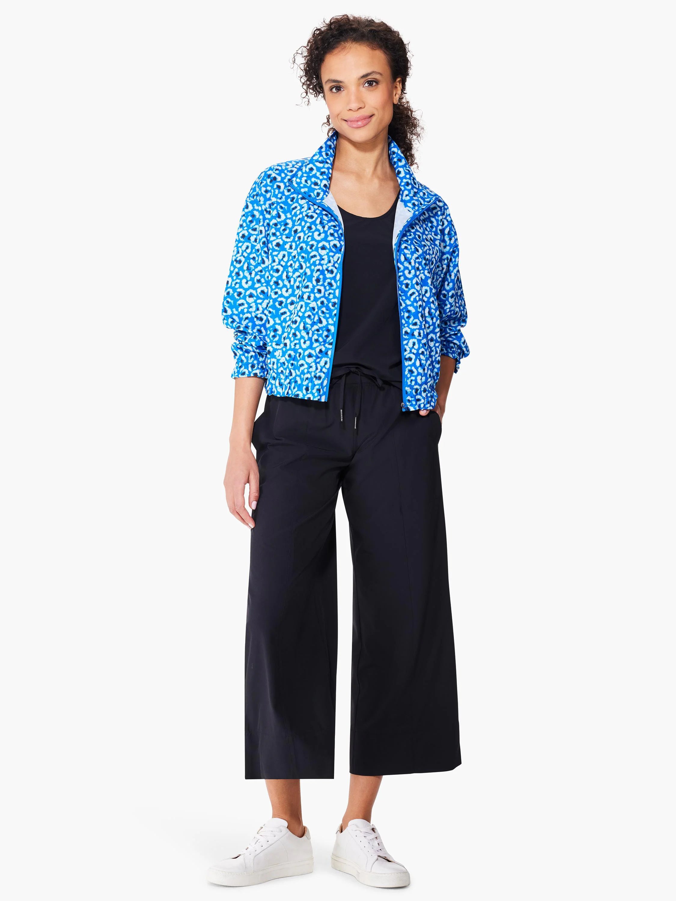Blue jacket with white leopard print, black pants, and white sneakers.