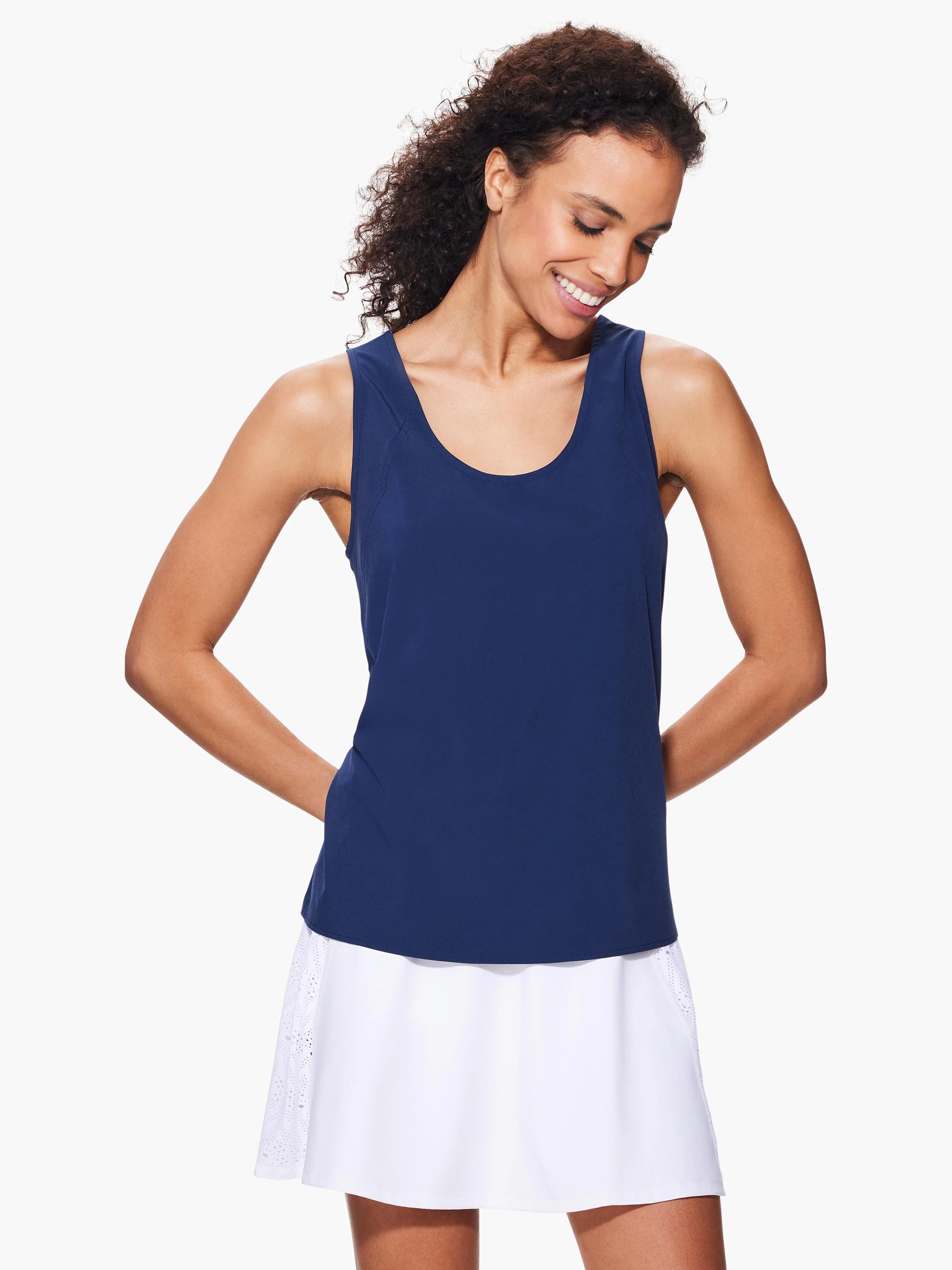 Navy blue sleeveless top, scoop neck. Paired with a white skirt with eyelet detail at the sides.