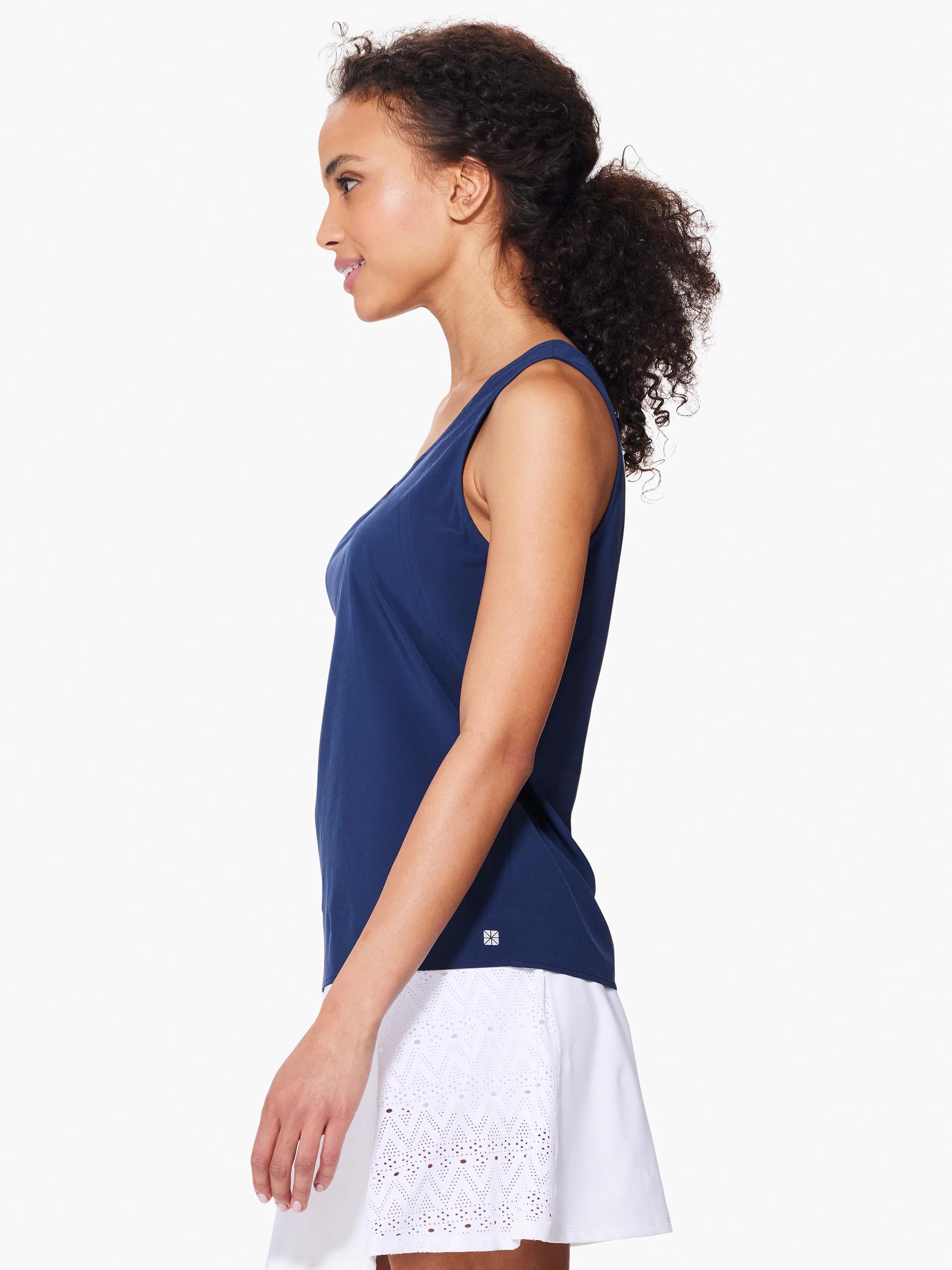 Navy blue sleeveless top, seamed detail. Model also wears white eyelet-trimmed skirt.