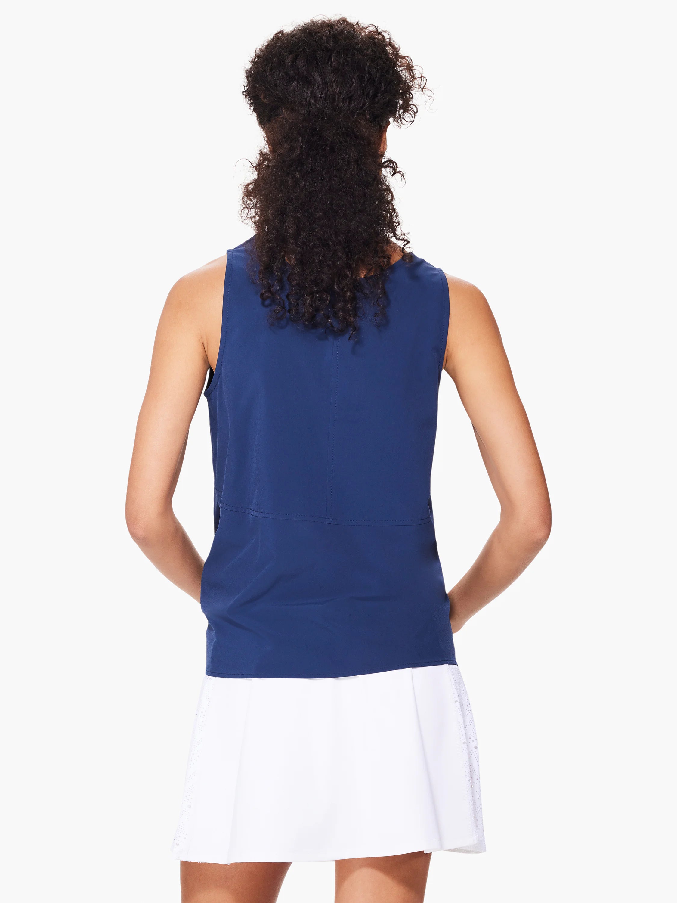 Navy blue sleeveless top, seamed detail at the waist. Model also wears a white eyelet-trimmed skirt.