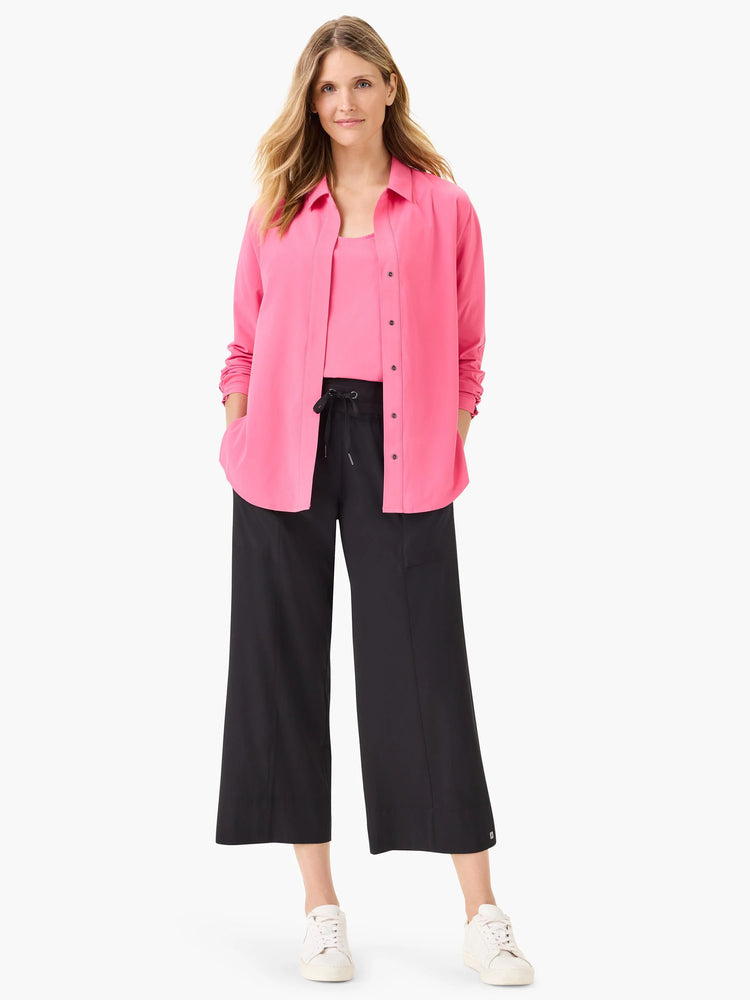 Bright pink collared long-sleeve shirt with black buttons, worn unbuttoned.