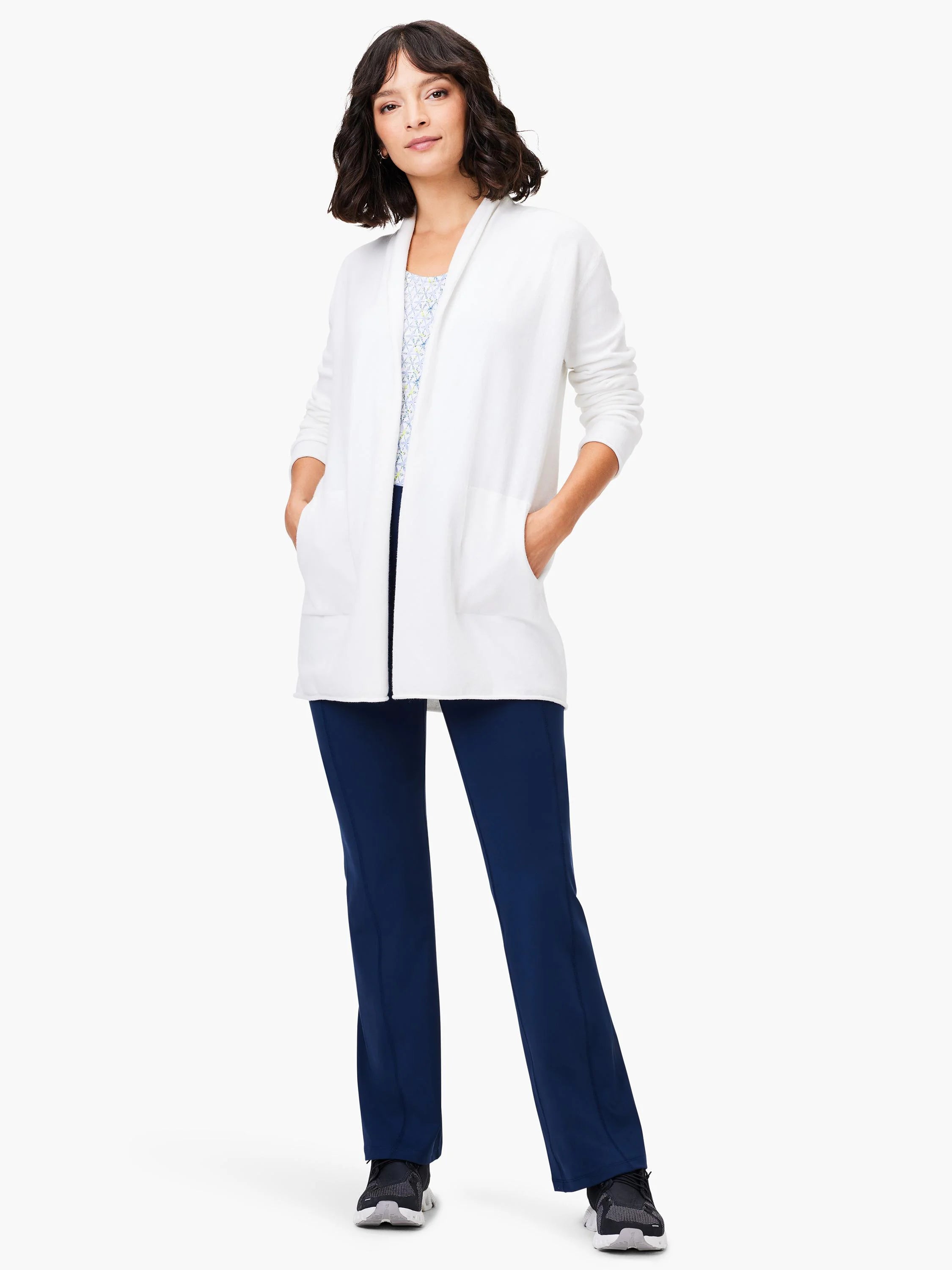 Off-white open-front cardigan with pockets, shown on a model wearing dark navy pants and sneakers.