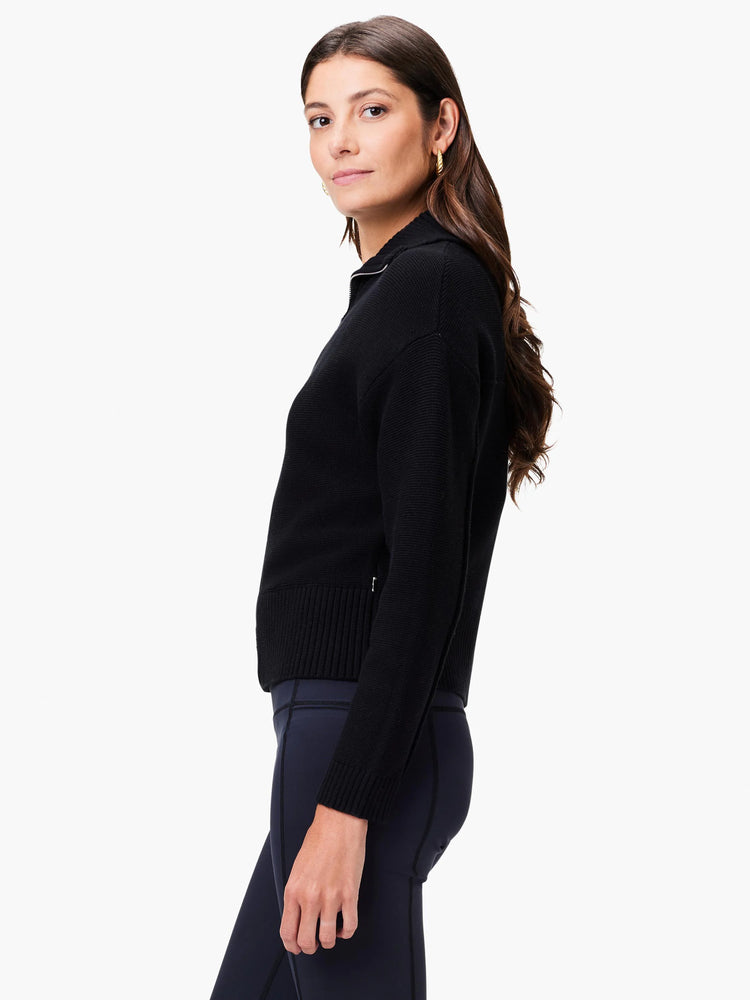 Black zip-front sweater jacket, long sleeves, ribbed hem and cuffs. Model shown wearing it.