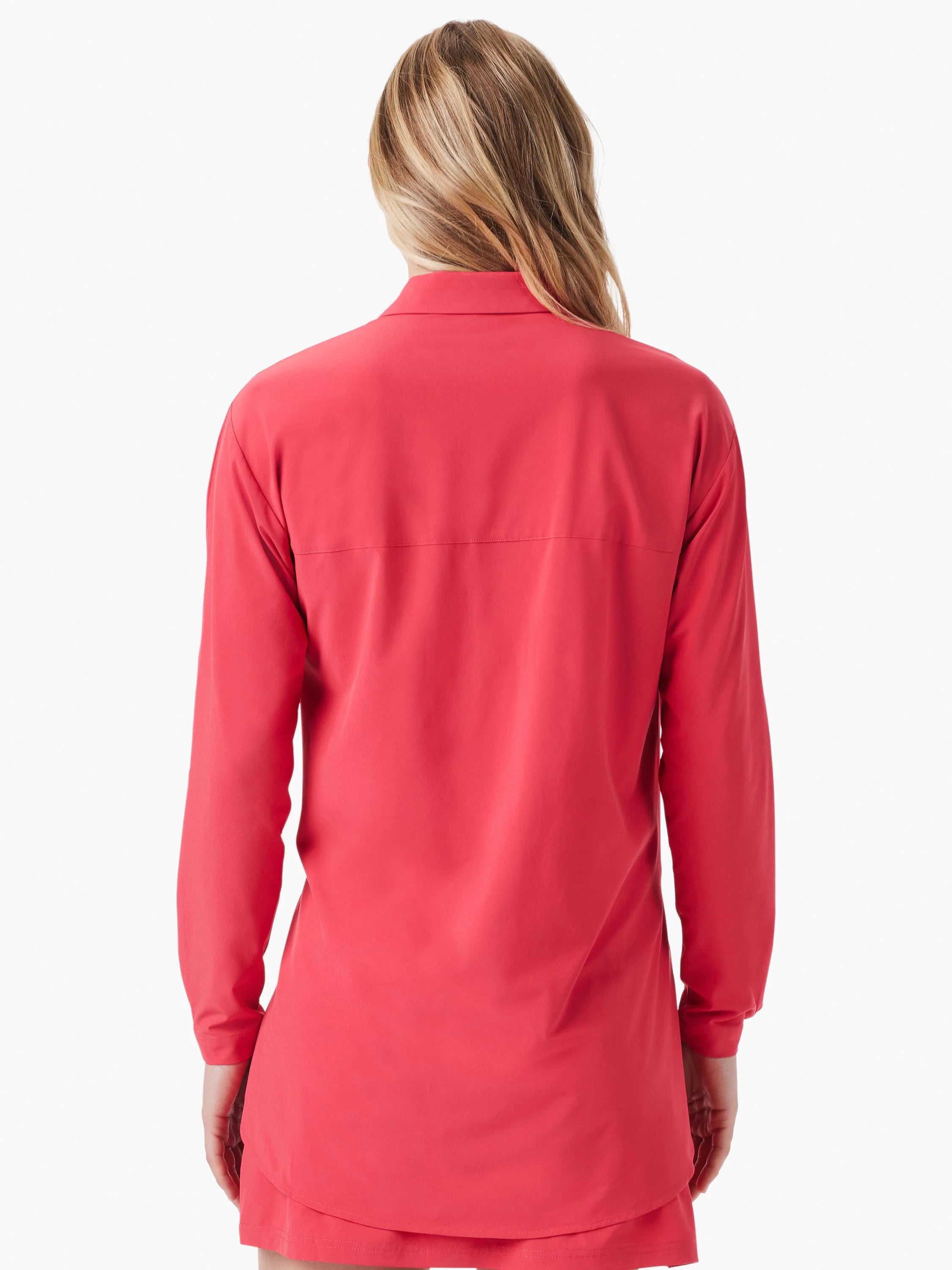 Back view of a woman wearing a coral red long-sleeve shirt with a collar and horizontal seam across the back.