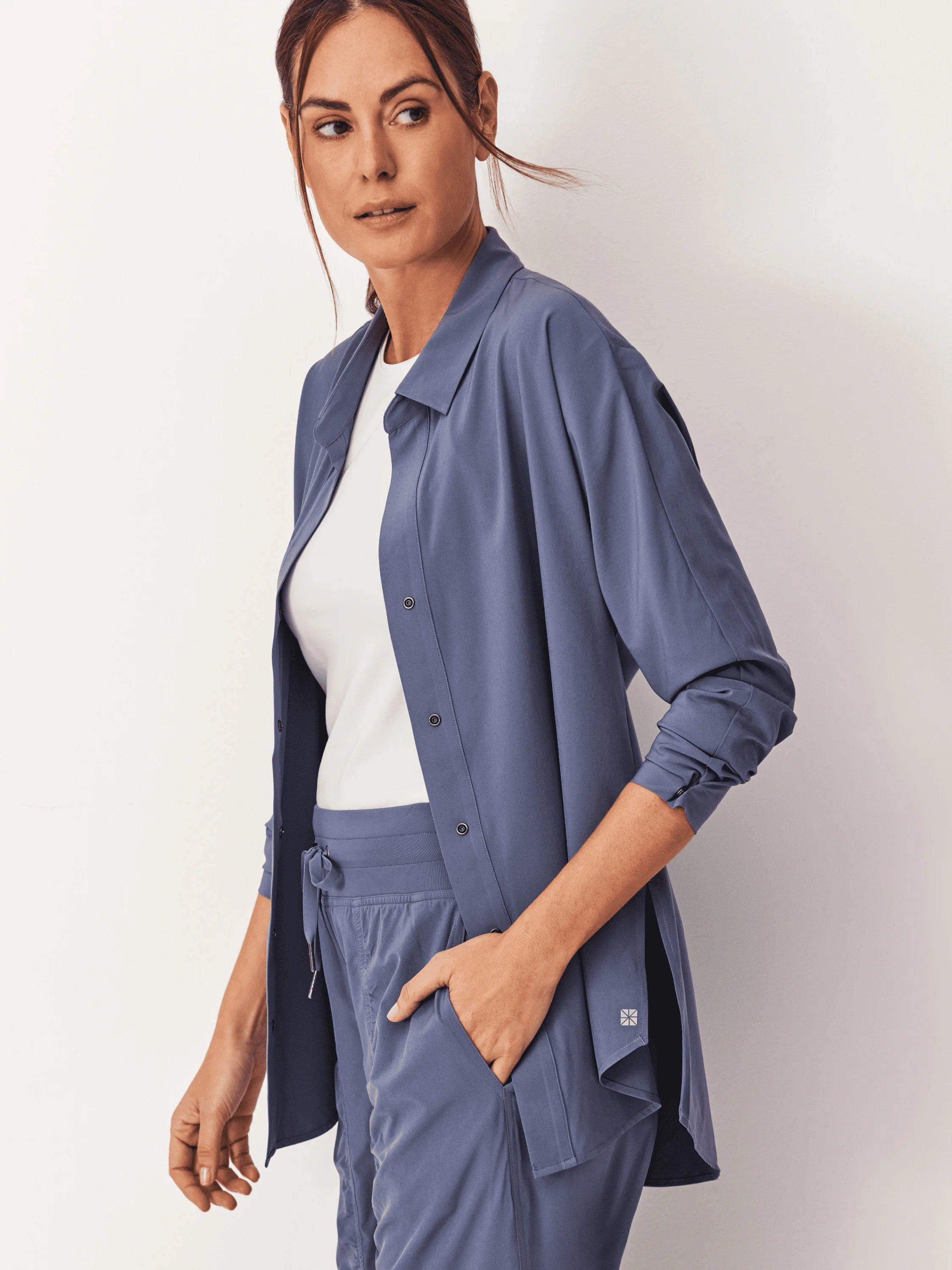 Slate blue, long-sleeved, collared button-front shirt with dark buttons, worn open over a white top. Relaxed fit.