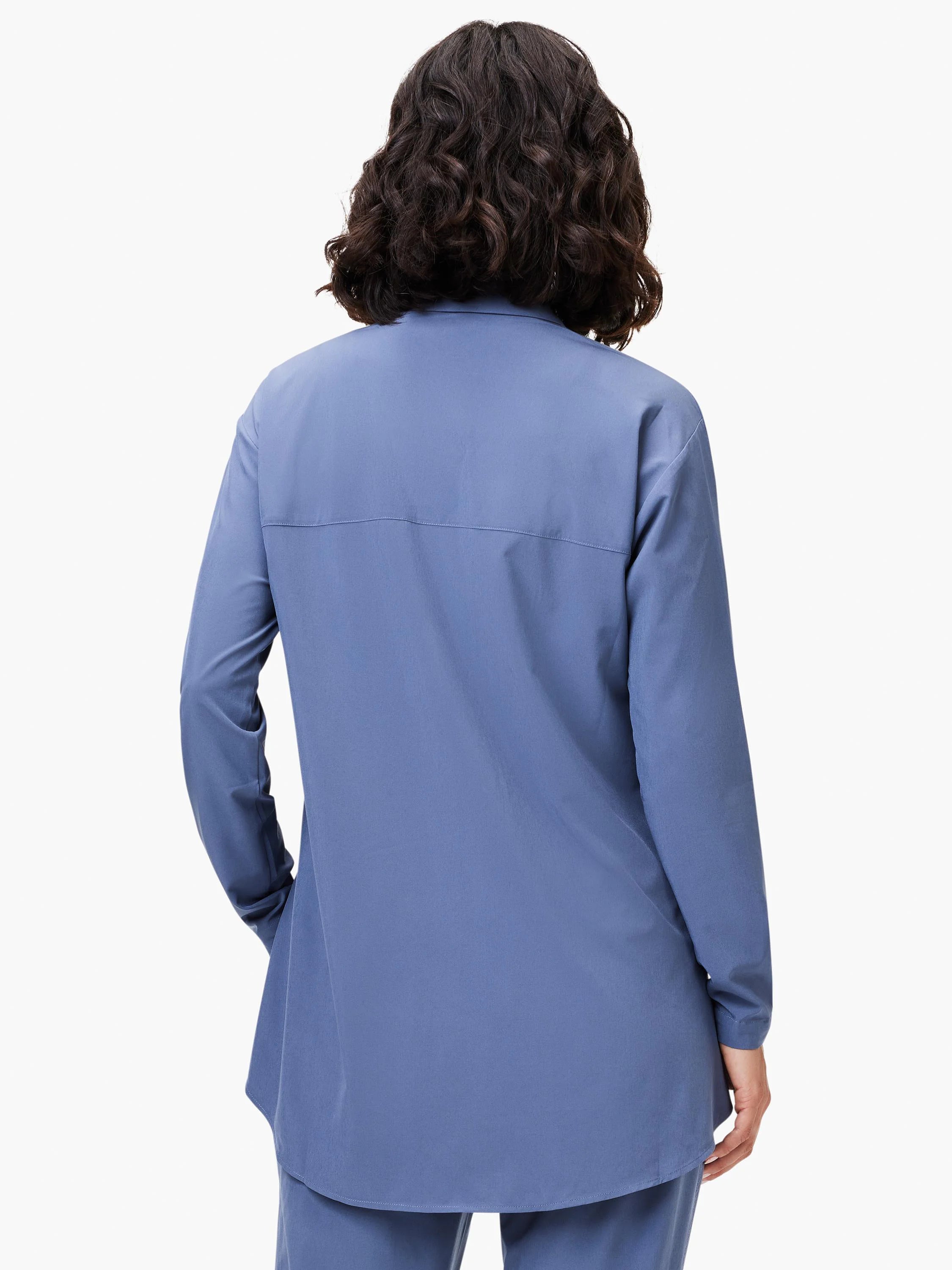 Muted blue long-sleeved shirt, back view, with a horizontal yoke seam and curved, longer hem.